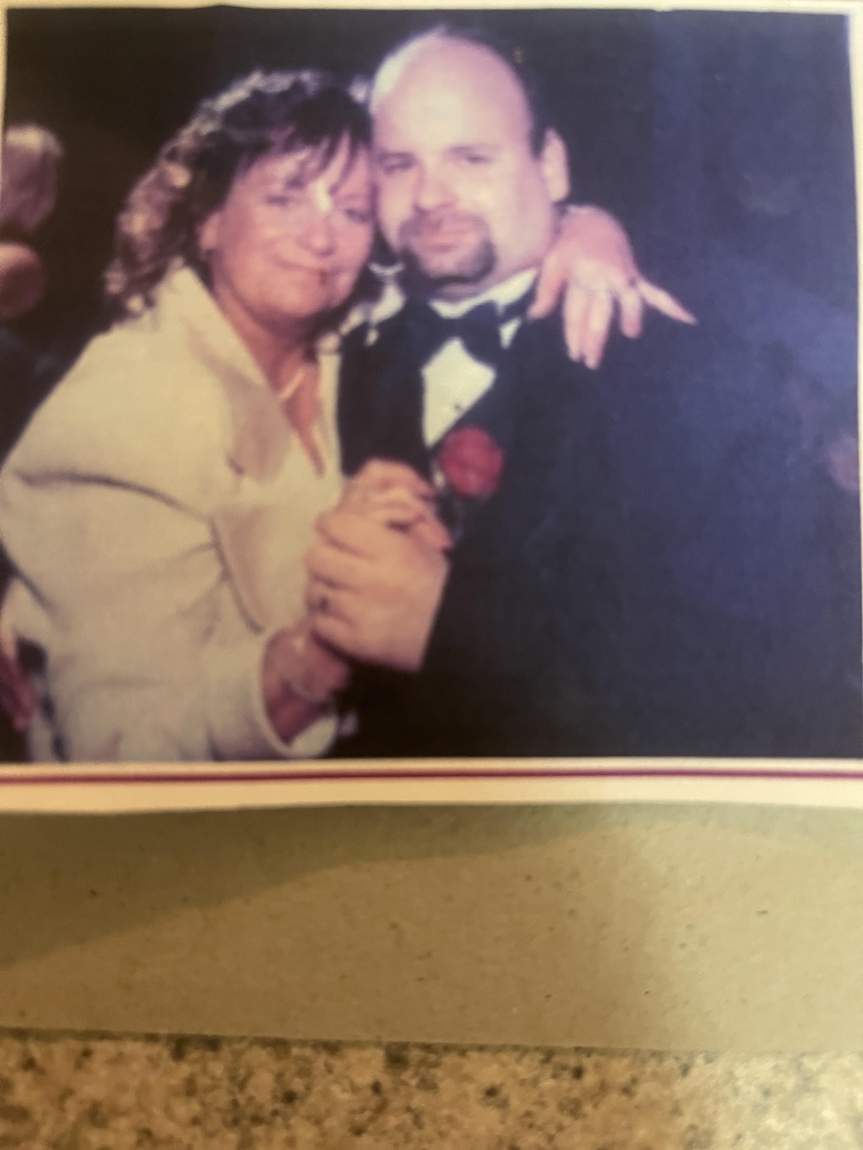 A couple shares a joyful dance together, celebrating their love at a nighttime event.