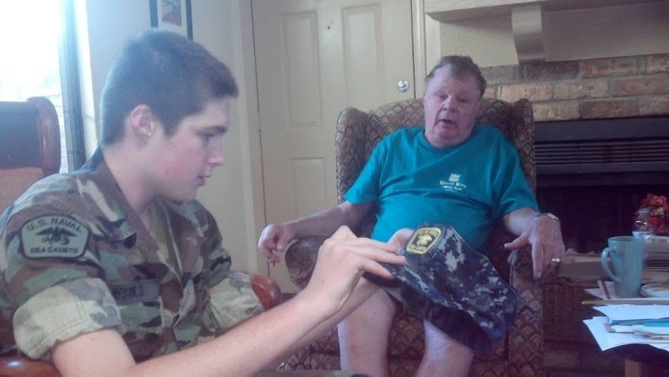 A young man in uniform discusses his military service while sitting near an older man.