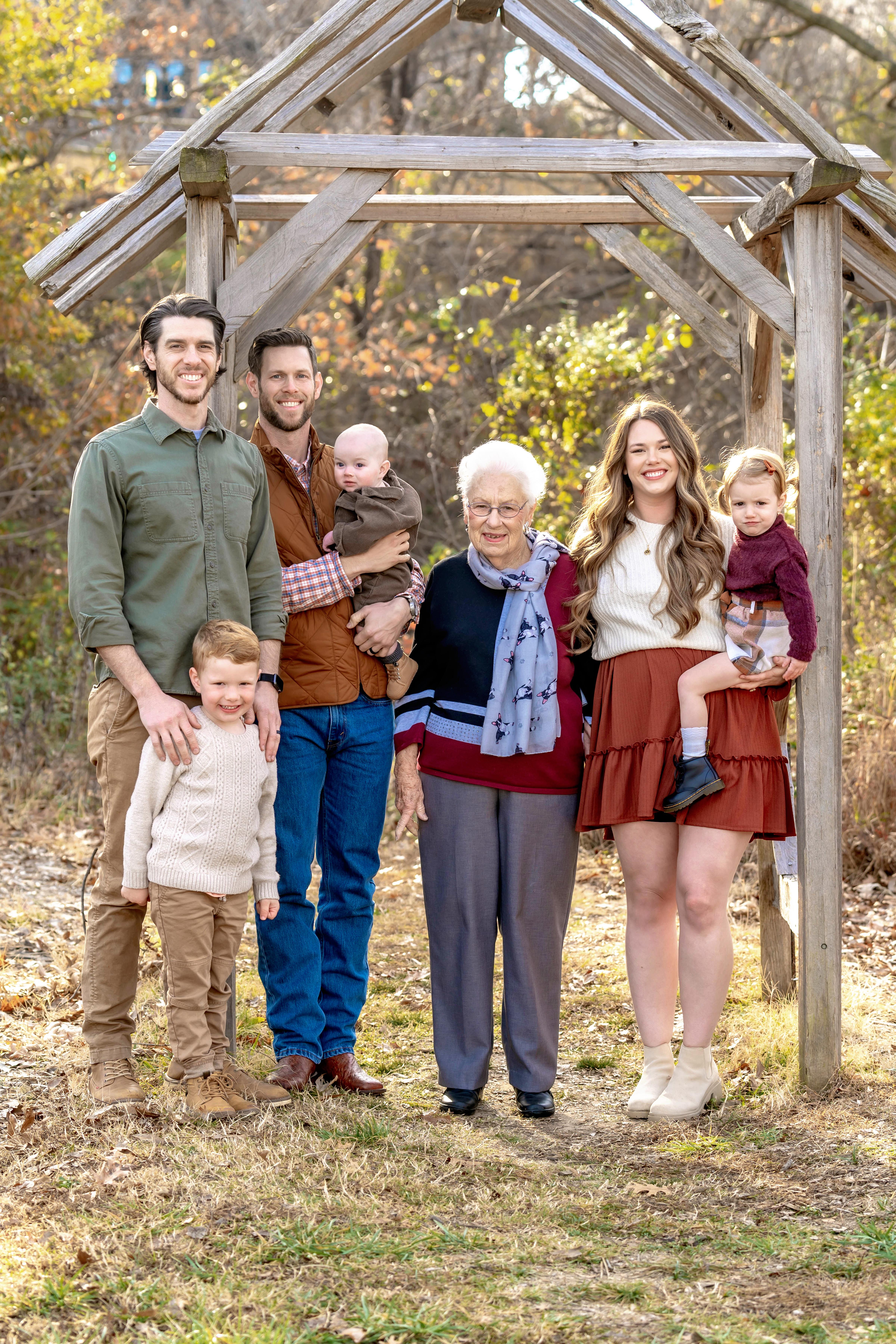 A joyful family stands together outdoors, capturing a special moment in a natural setting.