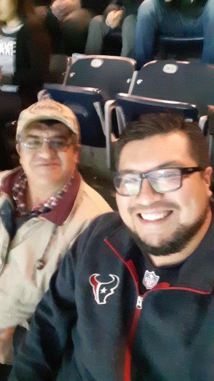 Two fans sit in the stands, cheering and smiling as they enjoy the excitement of the game.