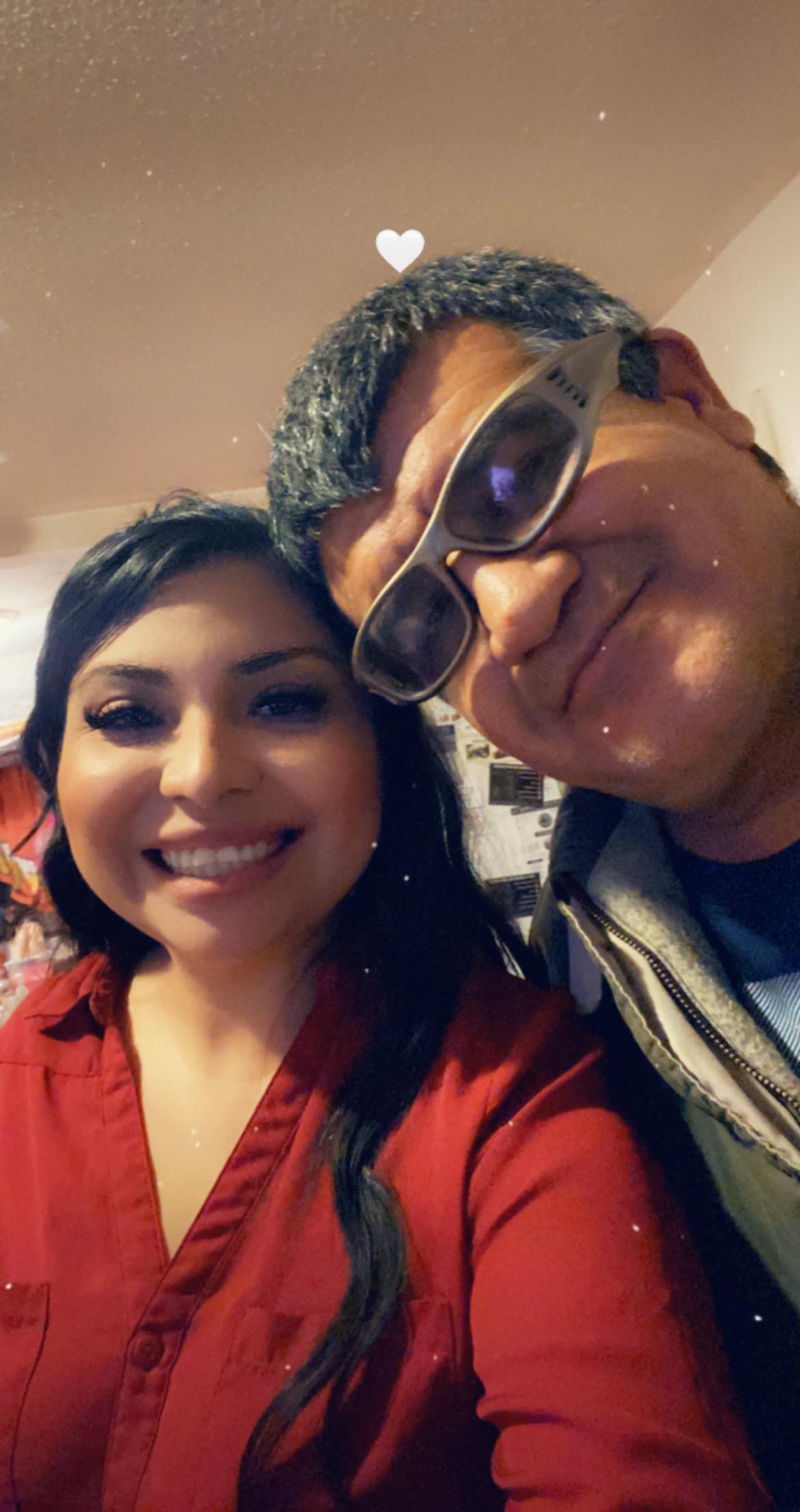 Two friends are enjoying a friendly moment, both smiling widely in a casual indoor environment.