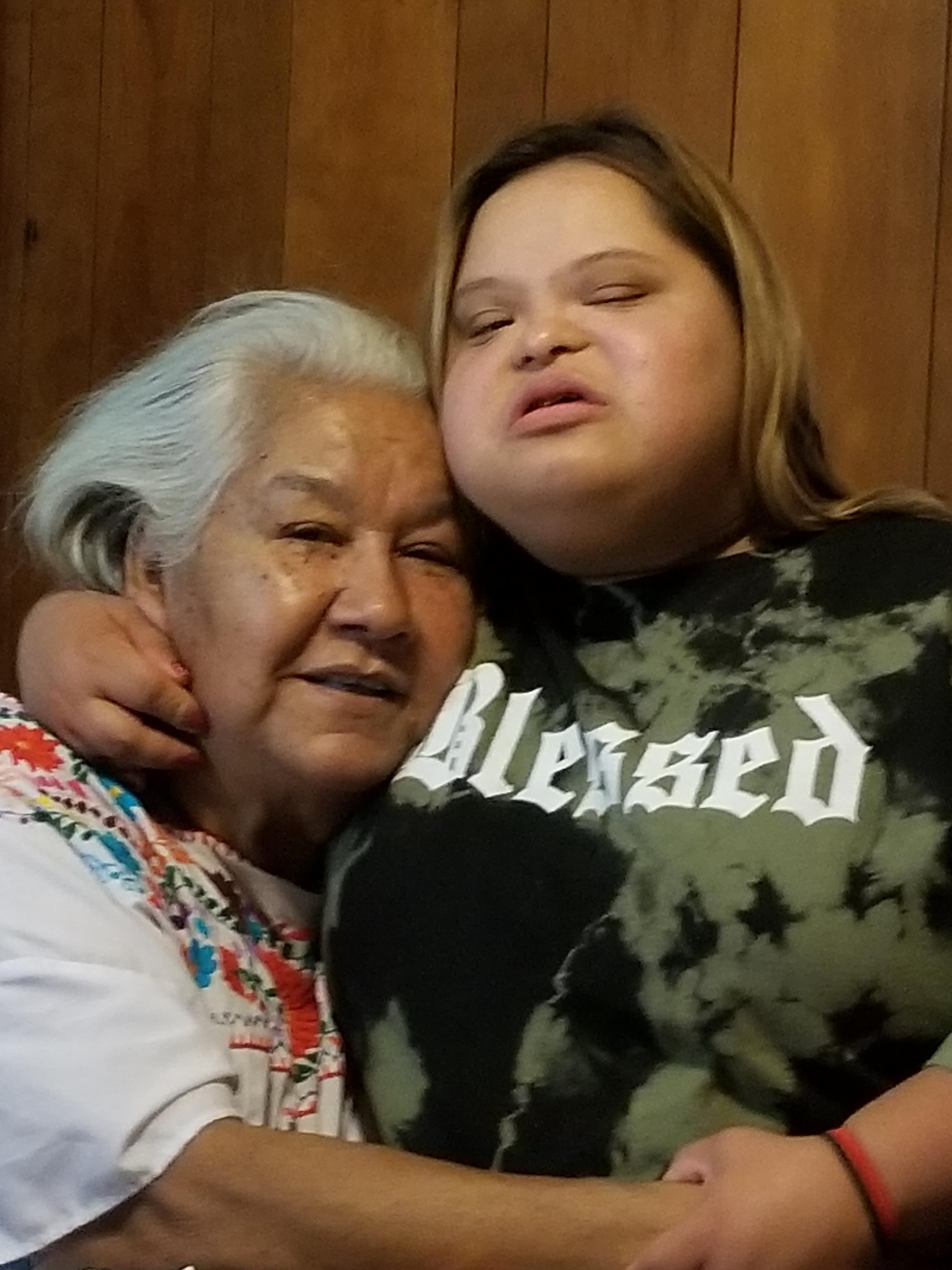 Two family members share a warm hug indoors, fostering a loving connection.