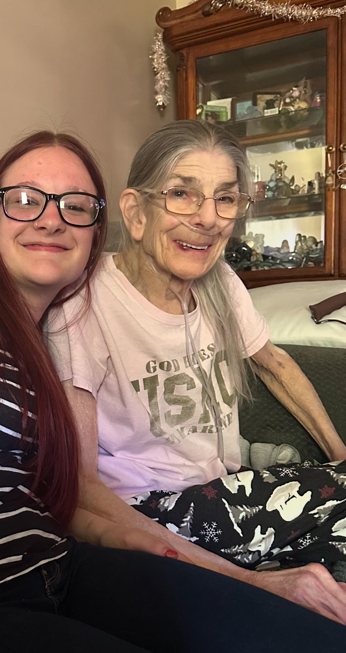 Two relatives smile happily, enjoying each other's company in a comfortable home environment.