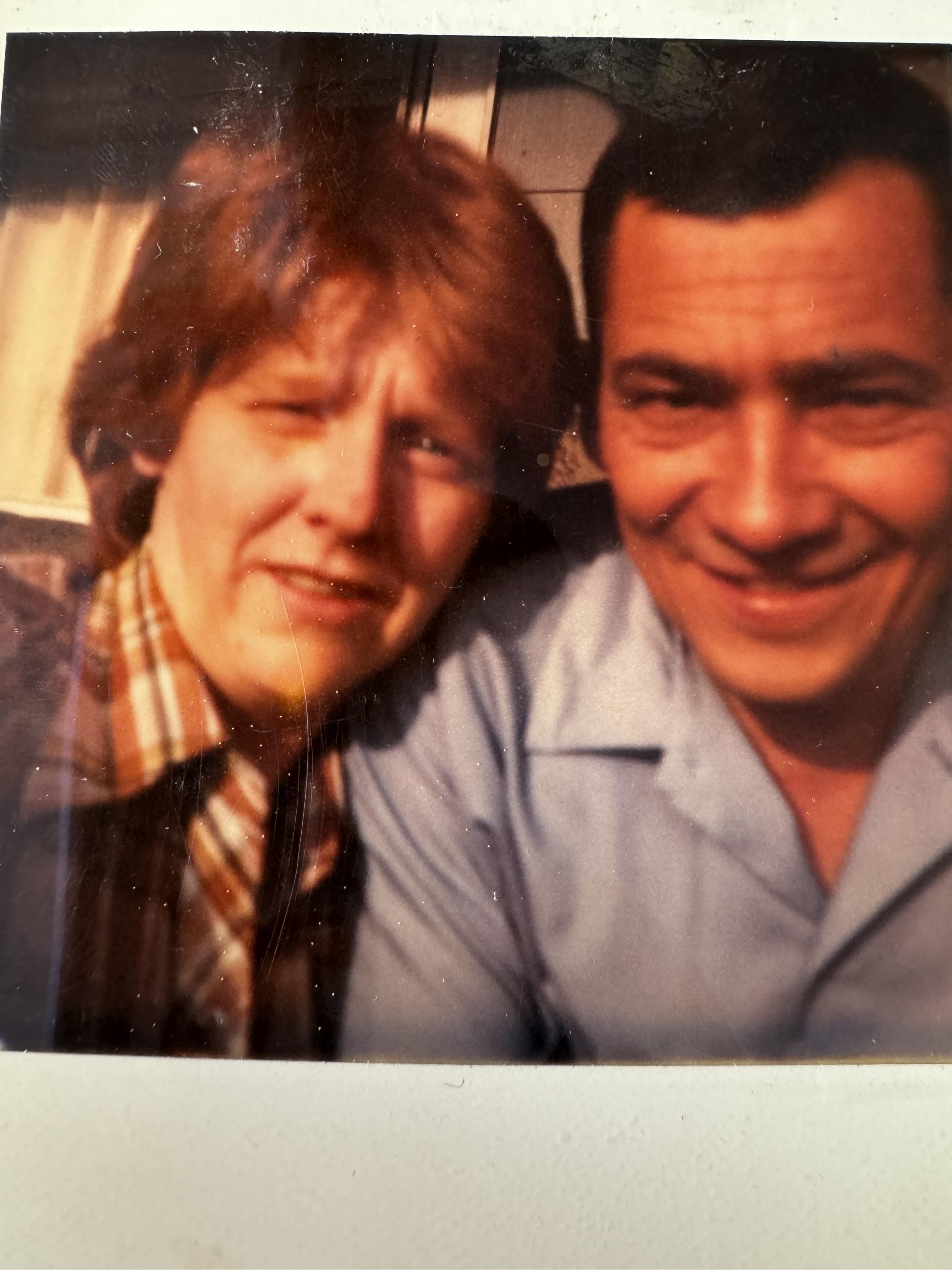 A couple shares a joyful moment outdoors, showcasing their friendship and happiness on a sunny day.