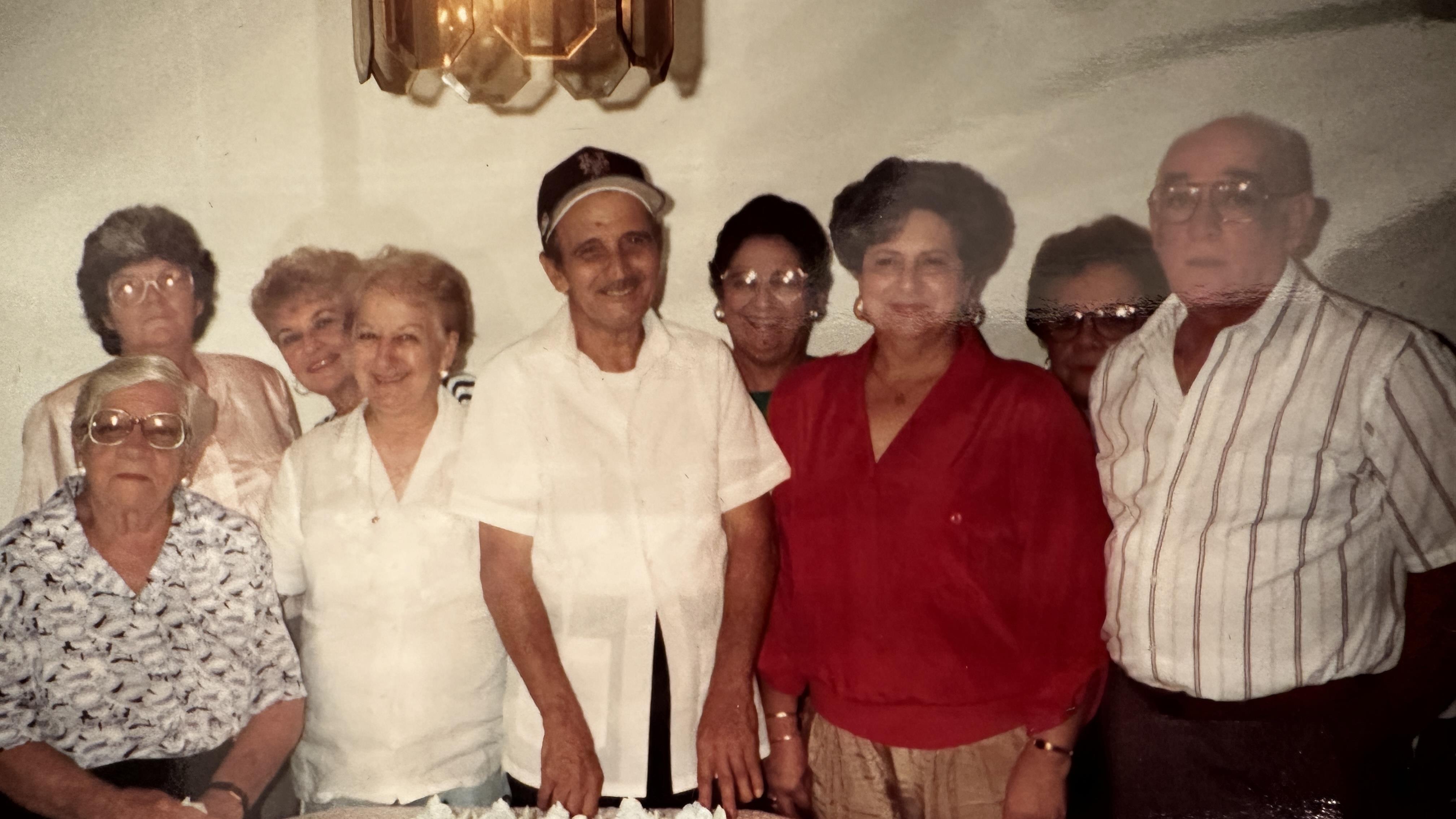 A group of senior friends enjoying time together, smiling and celebrating life in a warm setting.