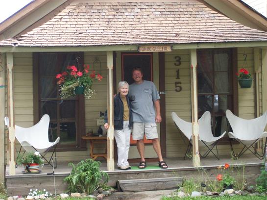 A man and woman standing on a porch