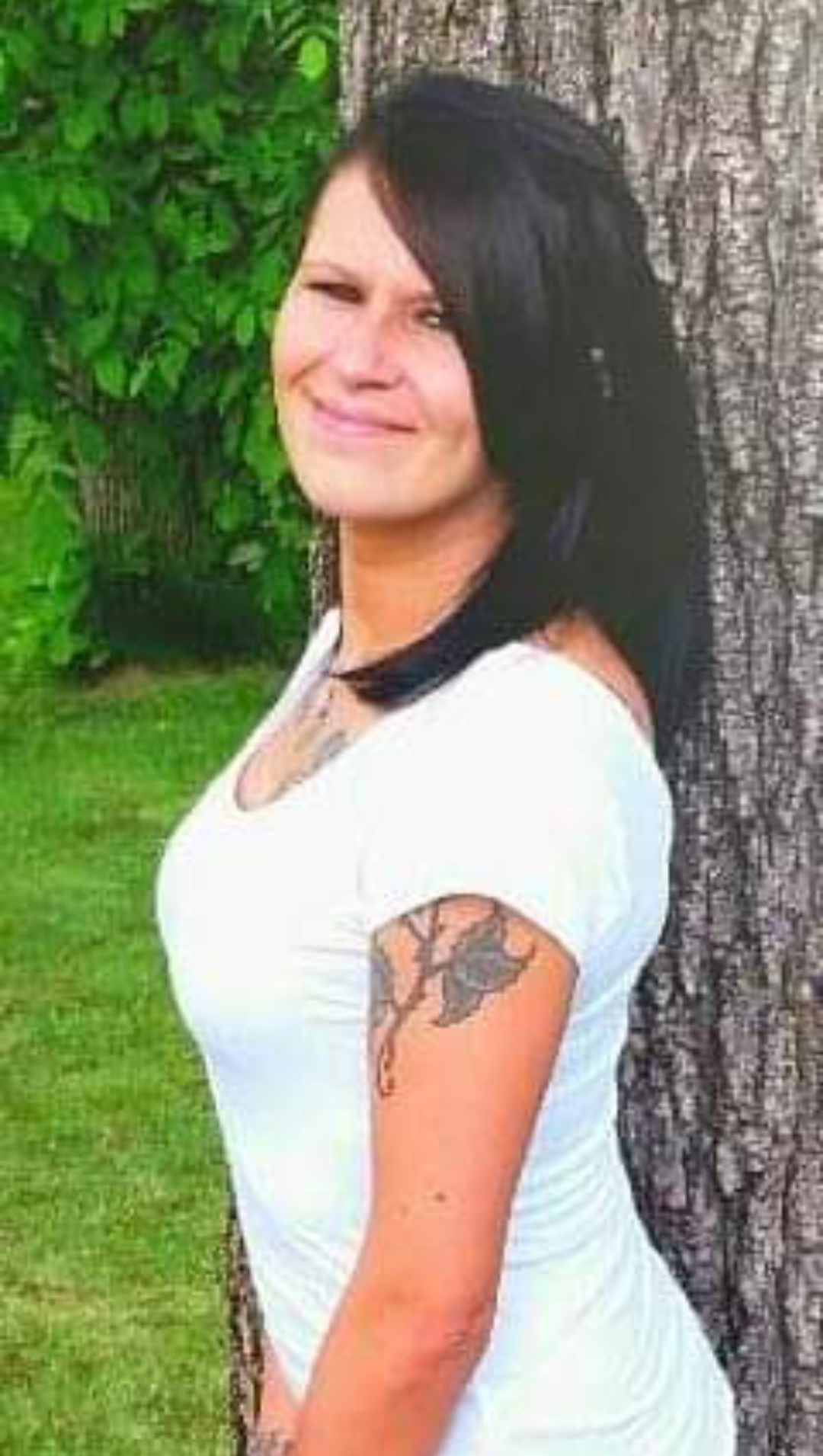 A woman standing next to a tree