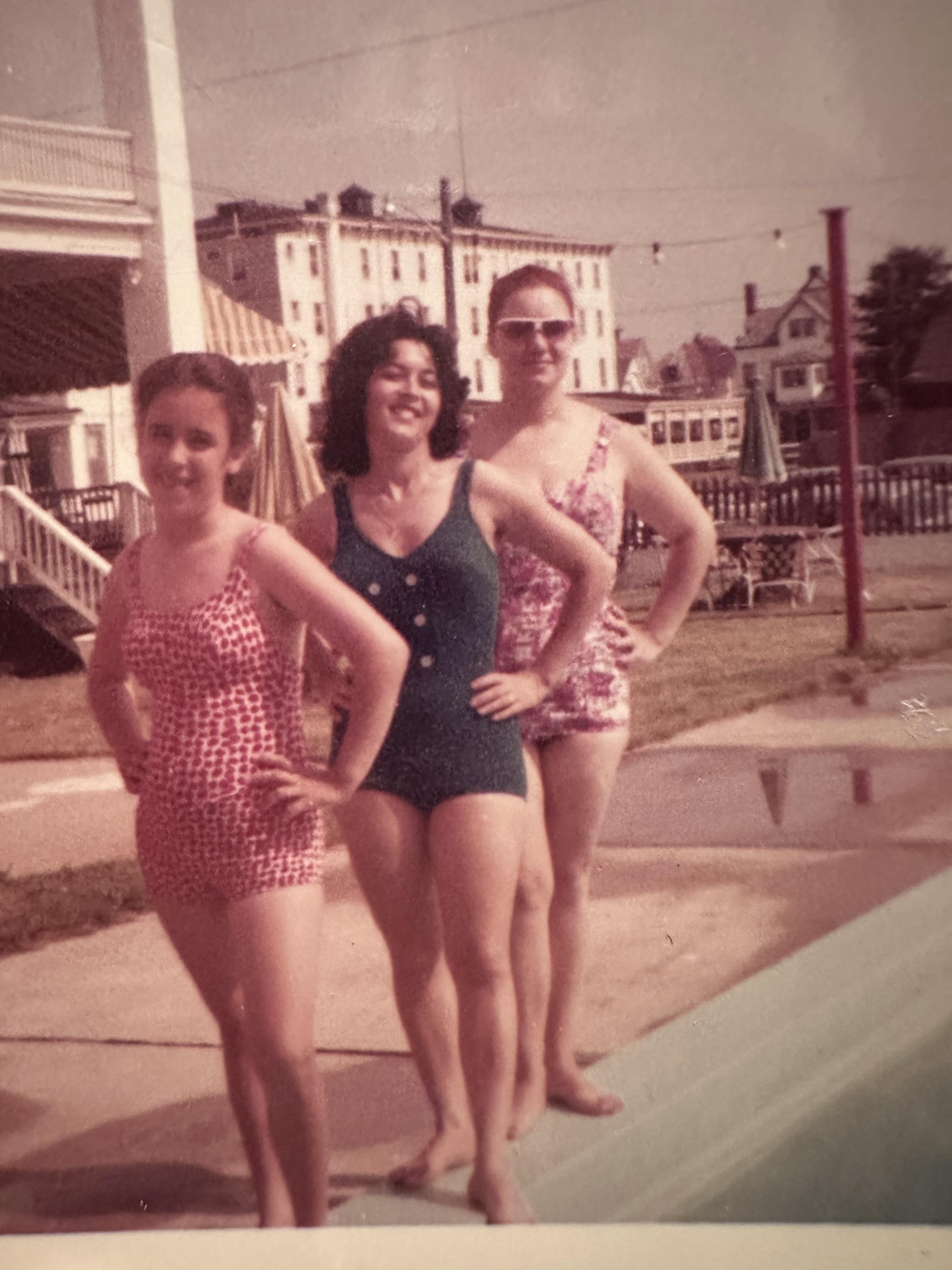 Three women pose confidently in swimsuits by a sunny poolside, showcasing summer fun and friendship.