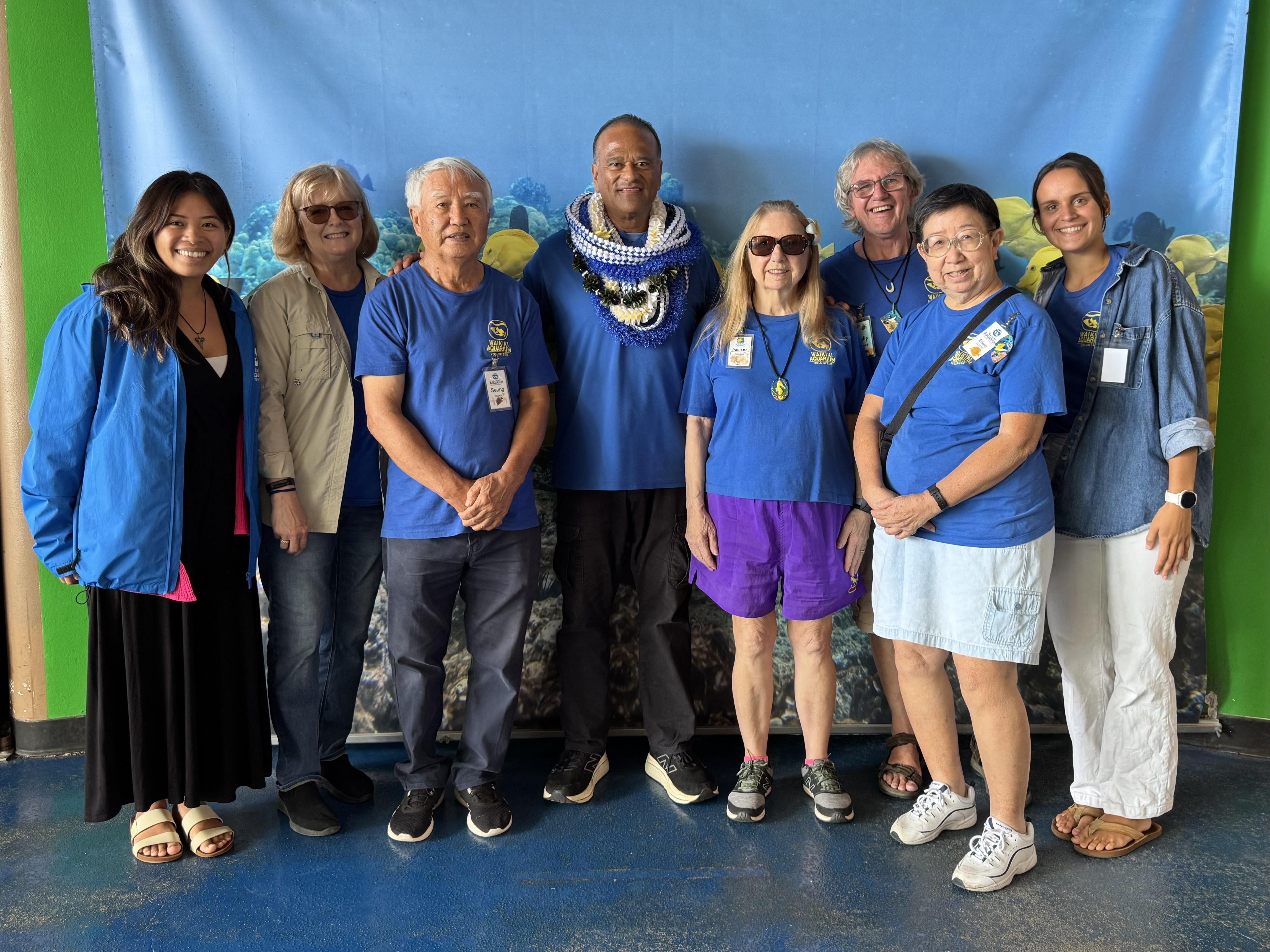 Volunteers gather for a group photo at a marine education center in Hawaii, showcasing teamwork.