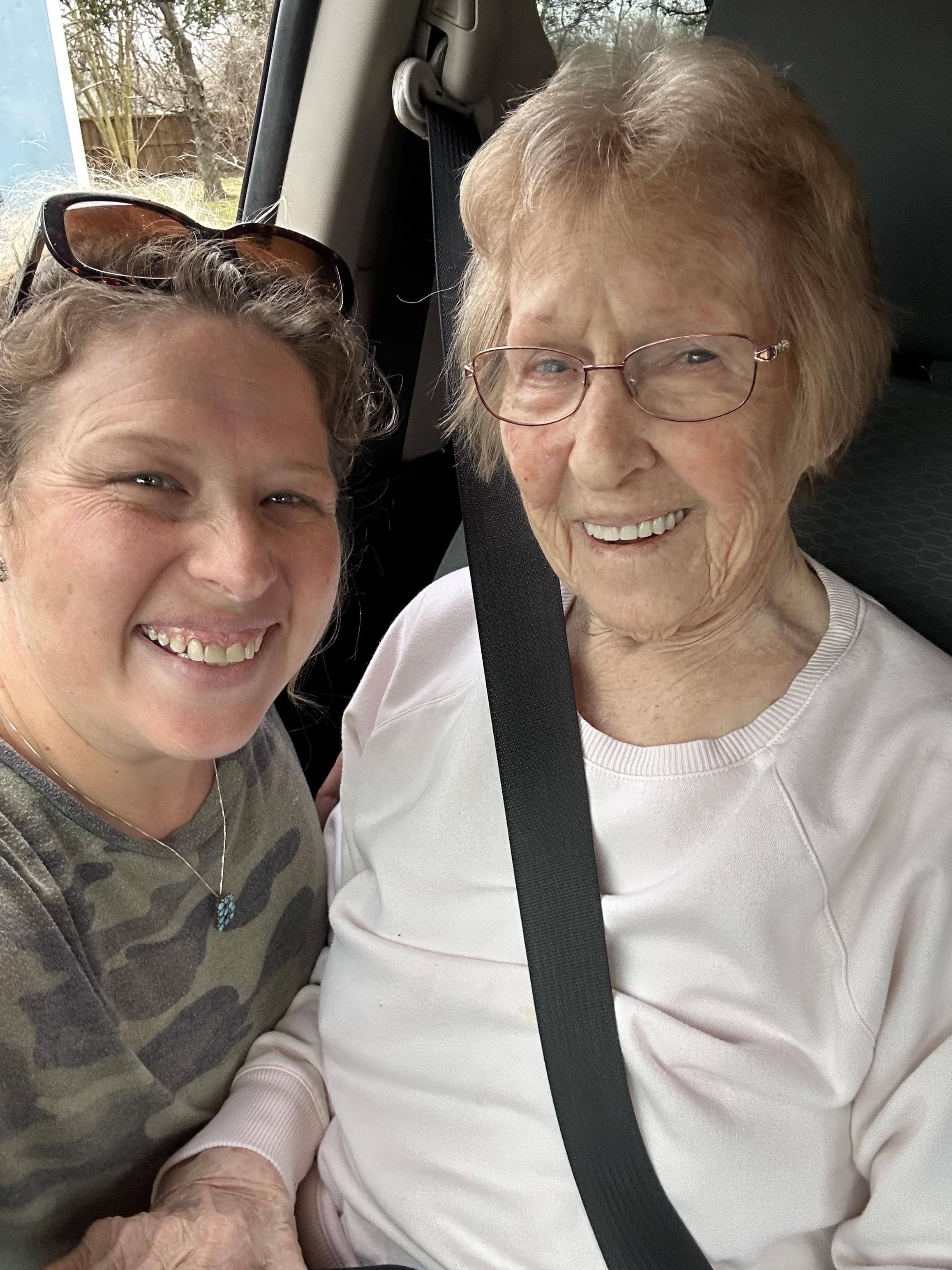Smiling senior woman enjoys a joyful moment with a family member in the car.