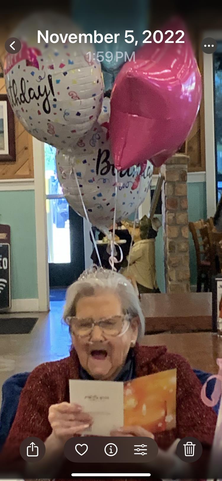 A lively birthday celebration takes place in a cozy restaurant with balloons and joyous expressions.