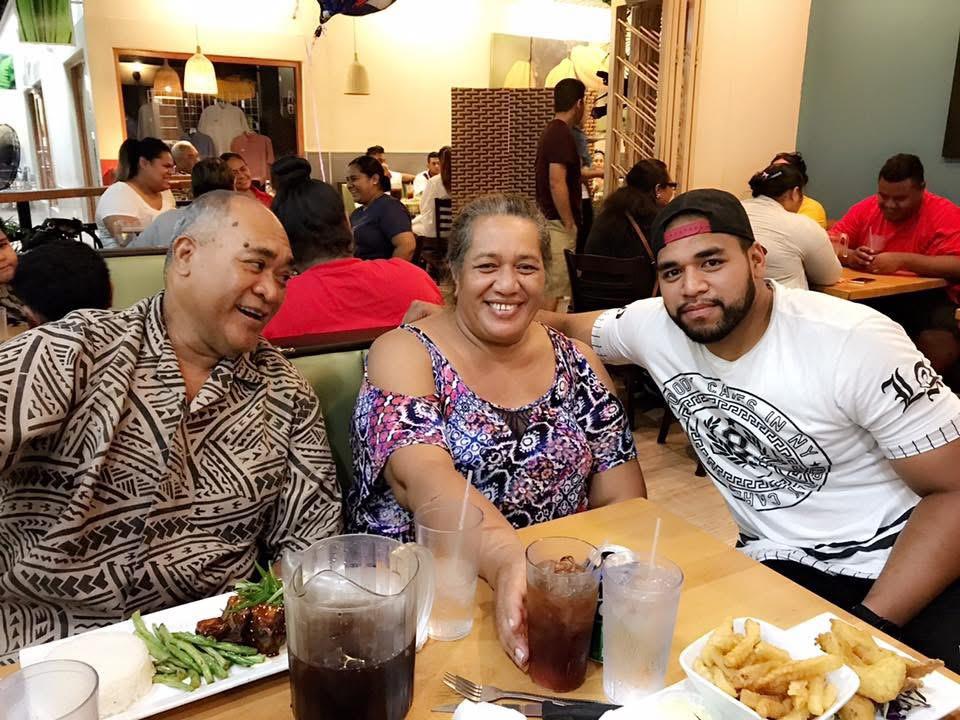 Three friends sharing laughs and food at a busy restaurant during dinner time.