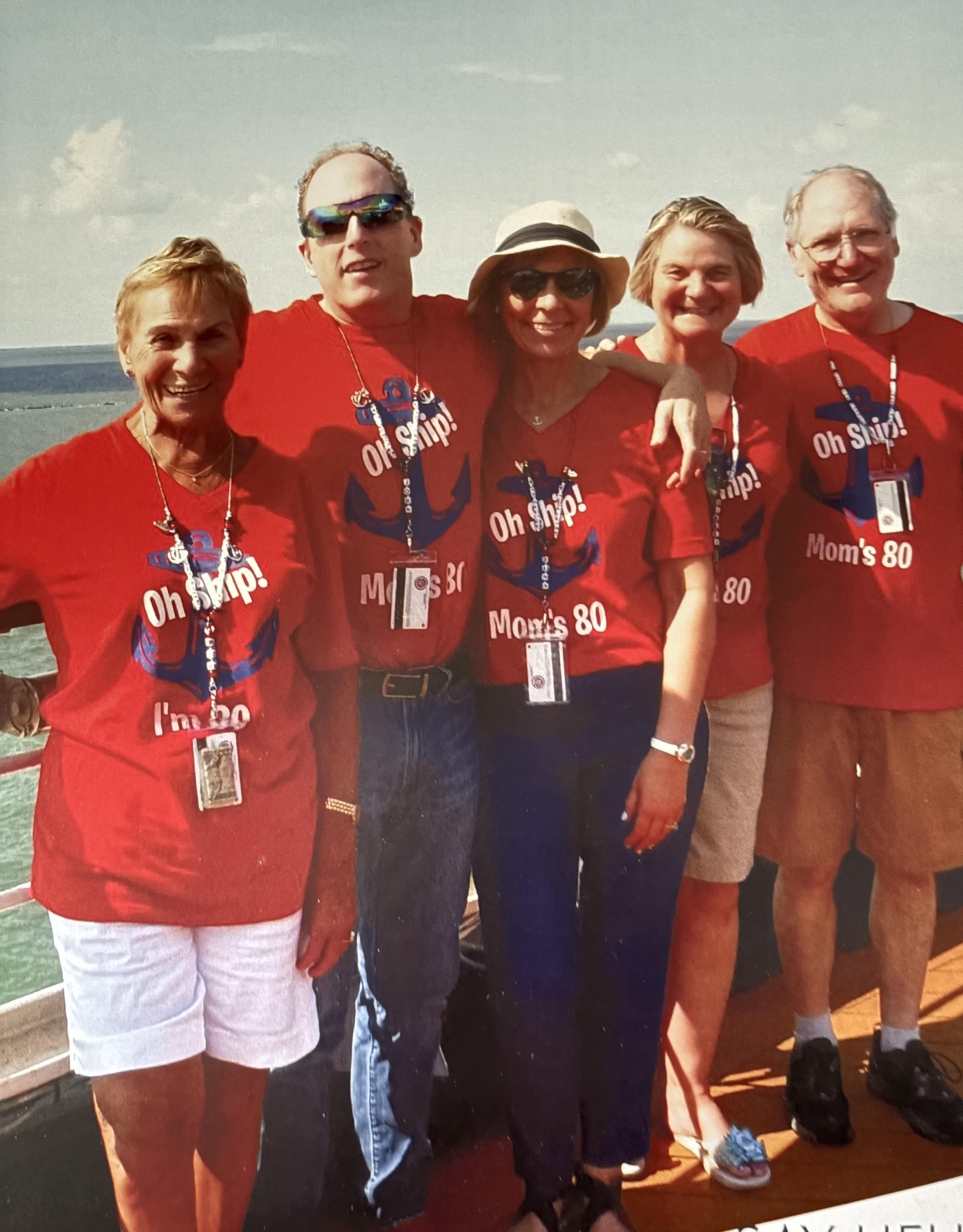 Family members gather together on a cruise deck, joyfully celebrating a special birthday event.