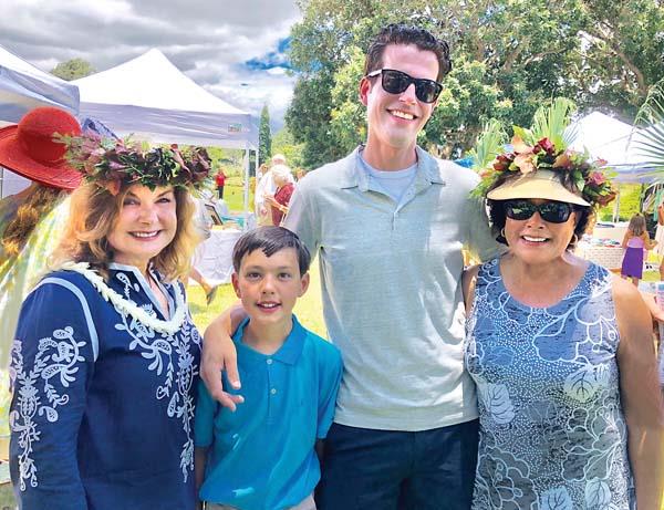 People enjoy an outdoor gathering, wearing festive hats and smiling under a bright sky.