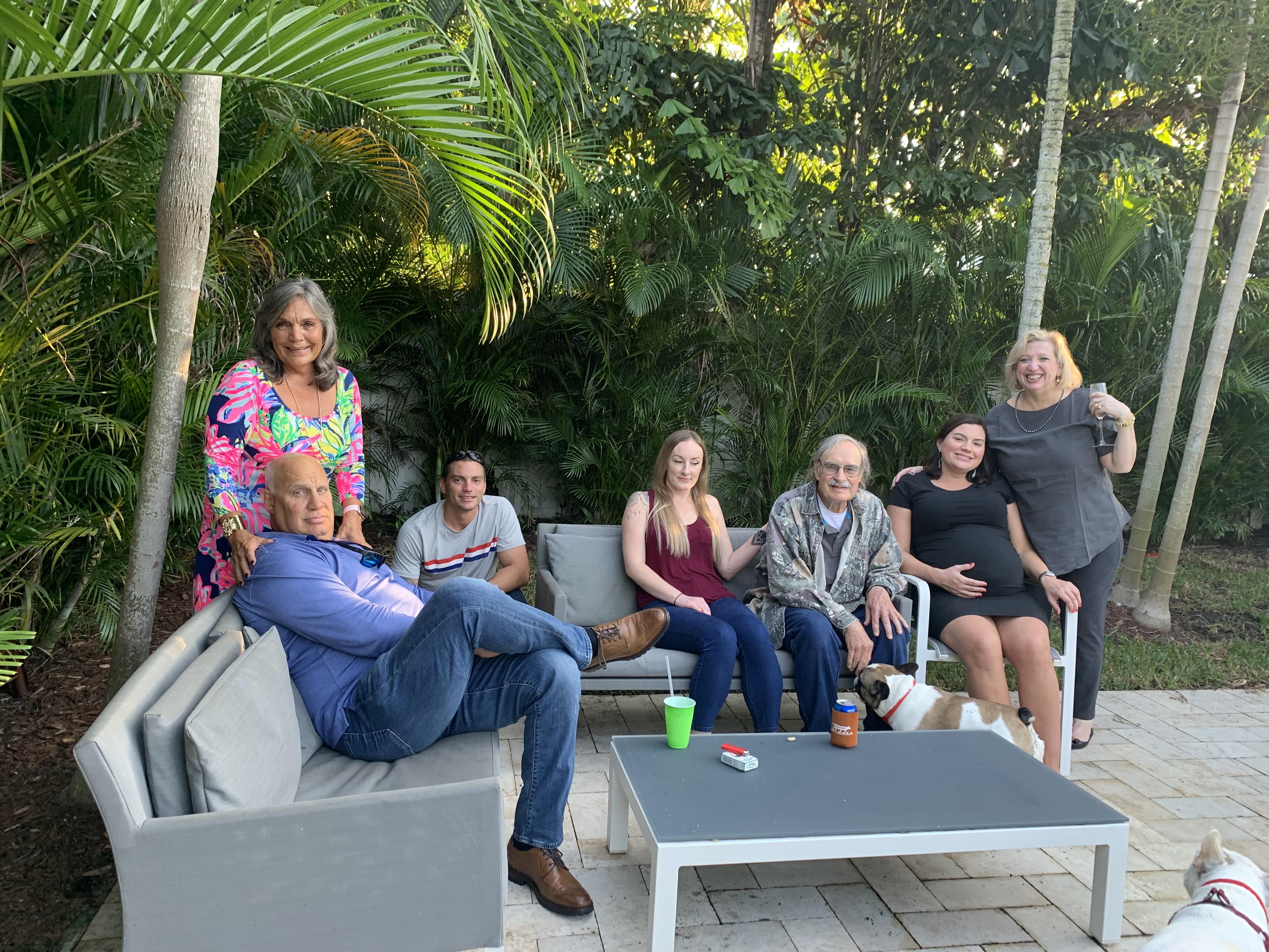 A group of family members enjoys a cheerful gathering together in a lush garden.