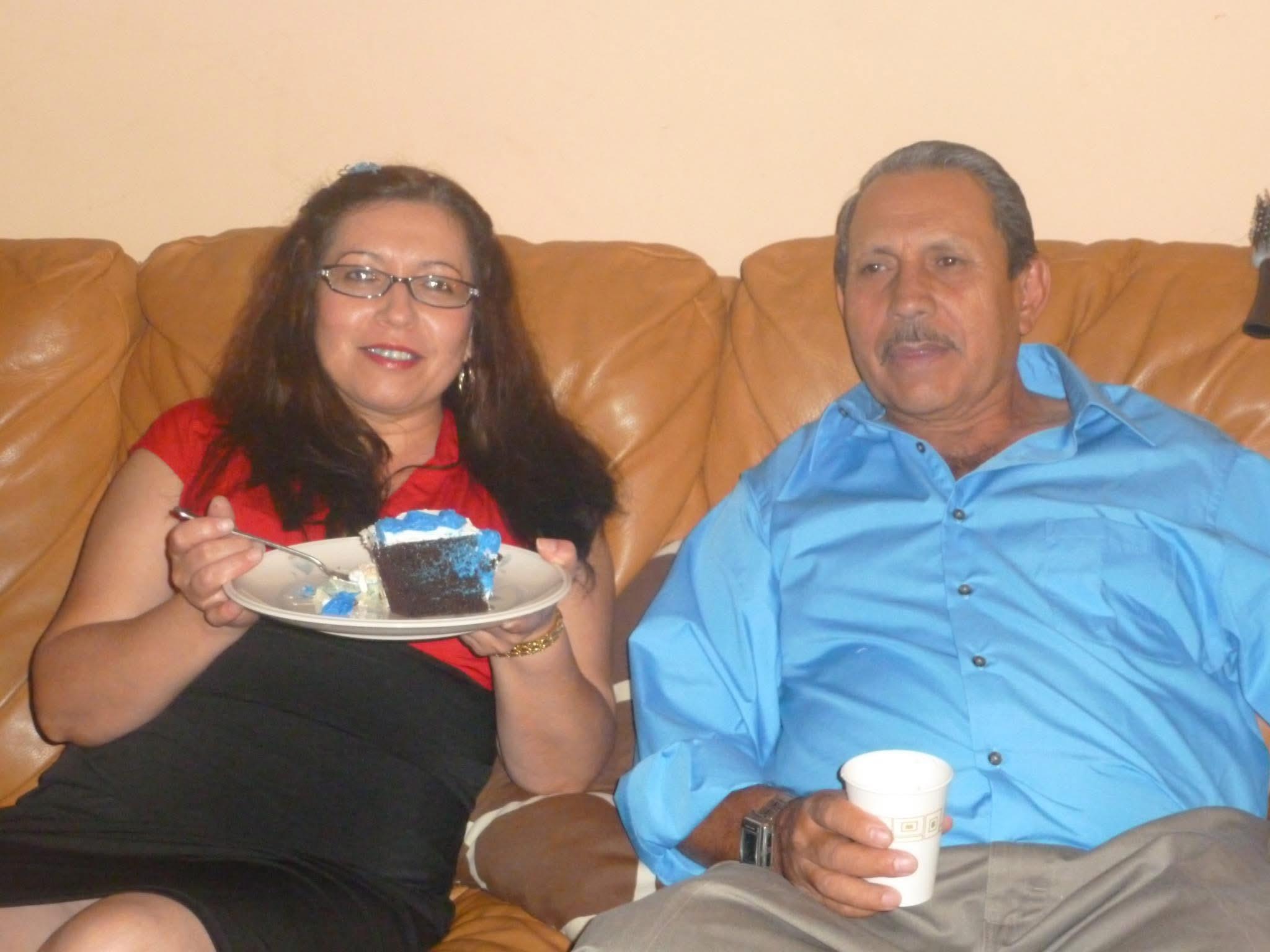 A couple enjoys a delightful dessert together while relaxing on a sofa in their home.