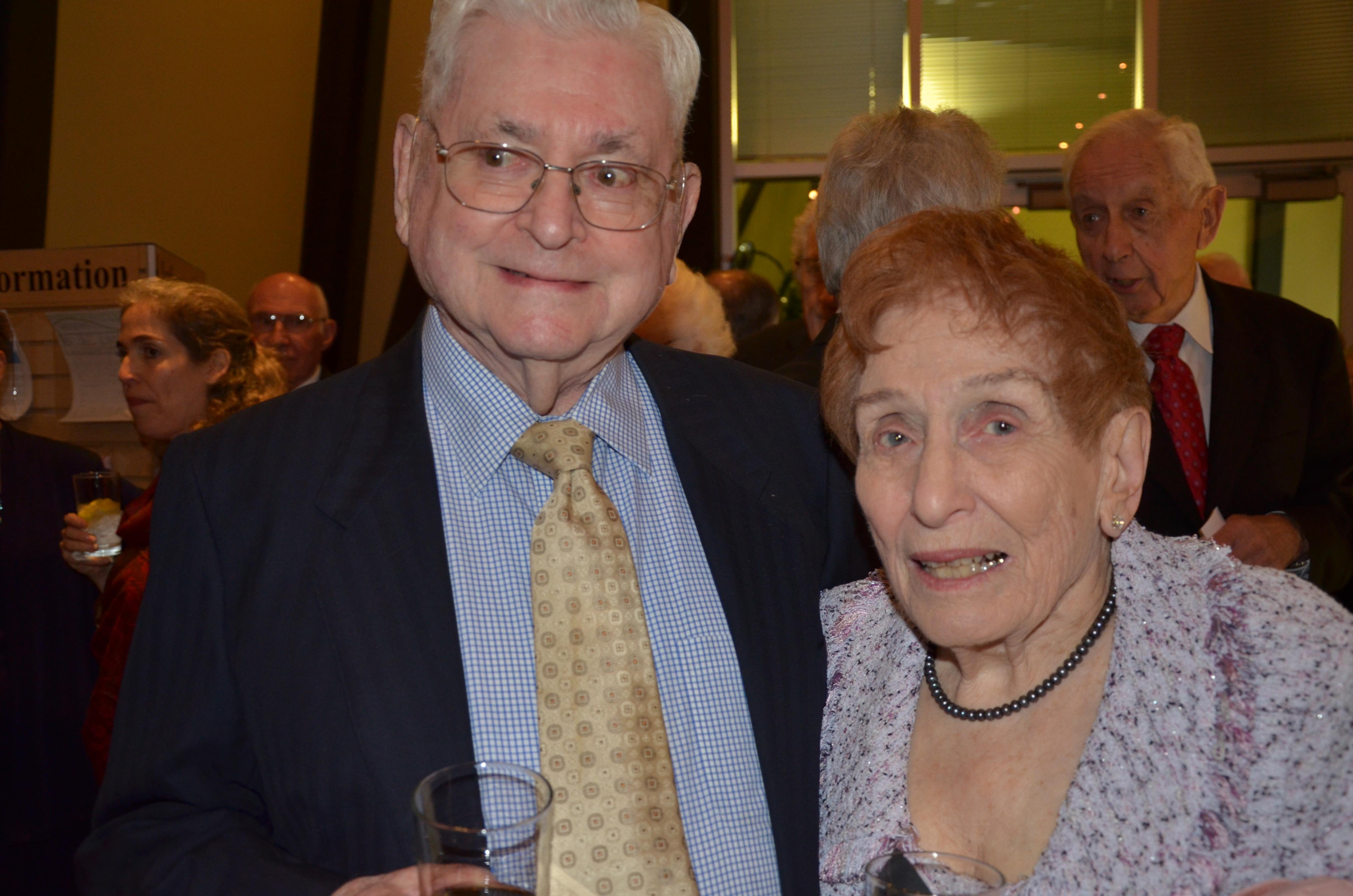 Smiling couple enjoys the company of friends during a lively celebration in the evening.