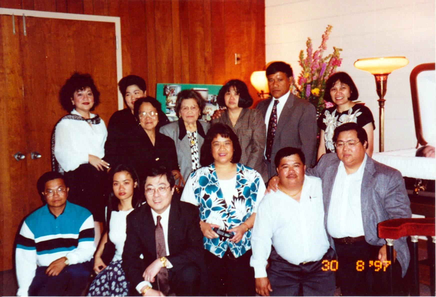 A joyful group poses for a memorable snapshot at a well-decorated indoor event.