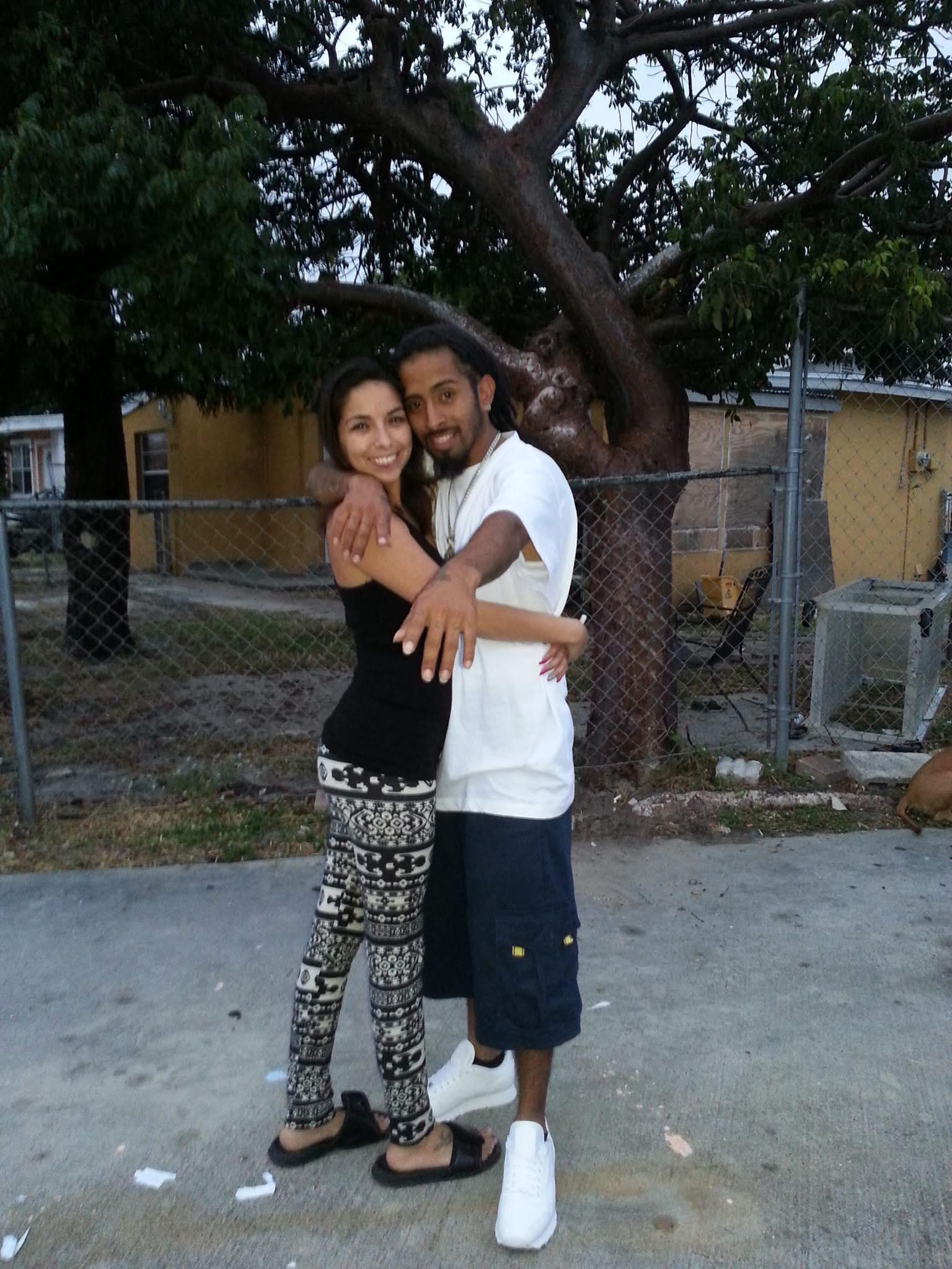 A couple shares a warm embrace outside as dusk settles over the neighborhood.