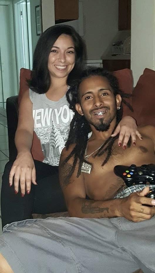 A man and woman relax on a sofa, playing video games and sharing smiles in a warm atmosphere.