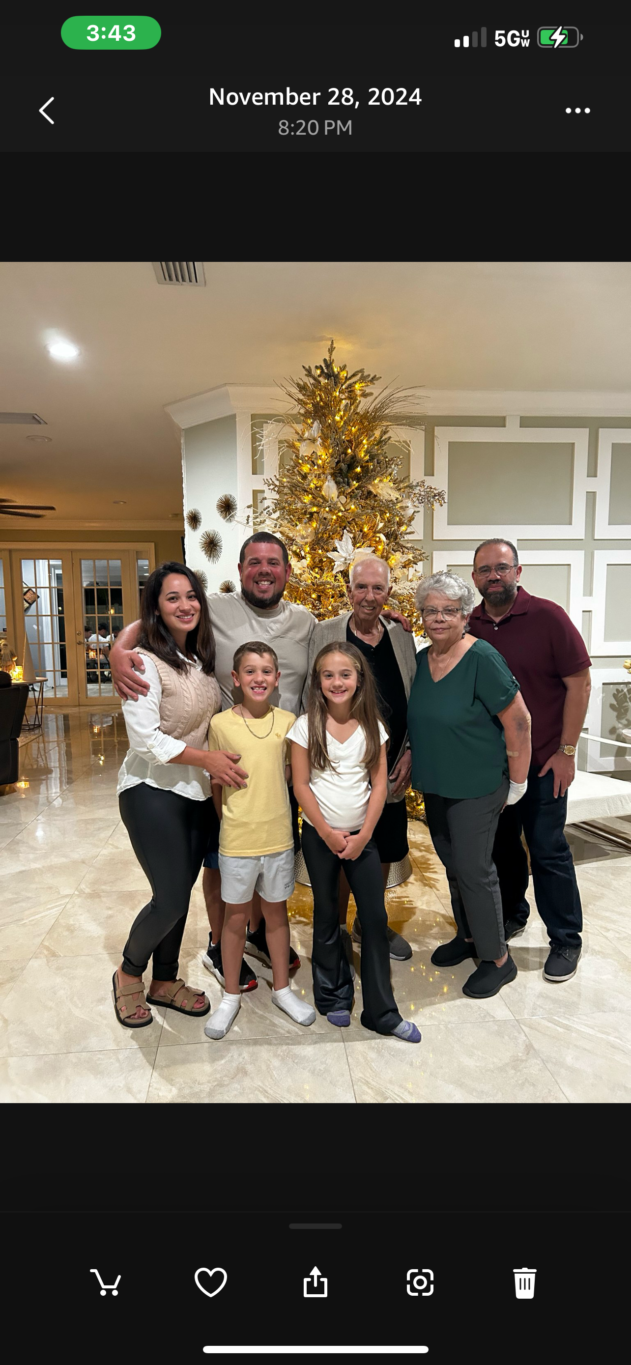 A cheerful family stands together in a festive living room adorned for the holidays.