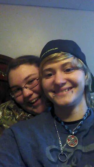 Two friends pose together, smiling and having fun in a cozy living room setting.