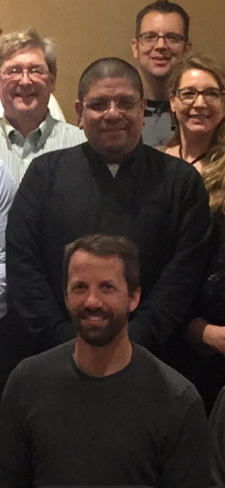 Professionals stand together in a conference room, engaging in discussions and forming connections.