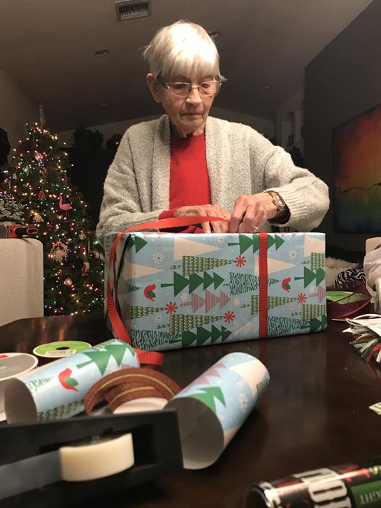 An old woman opening a present