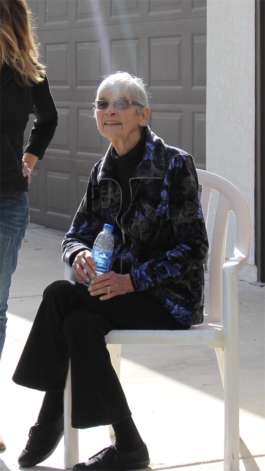An older woman sitting in a white chair
