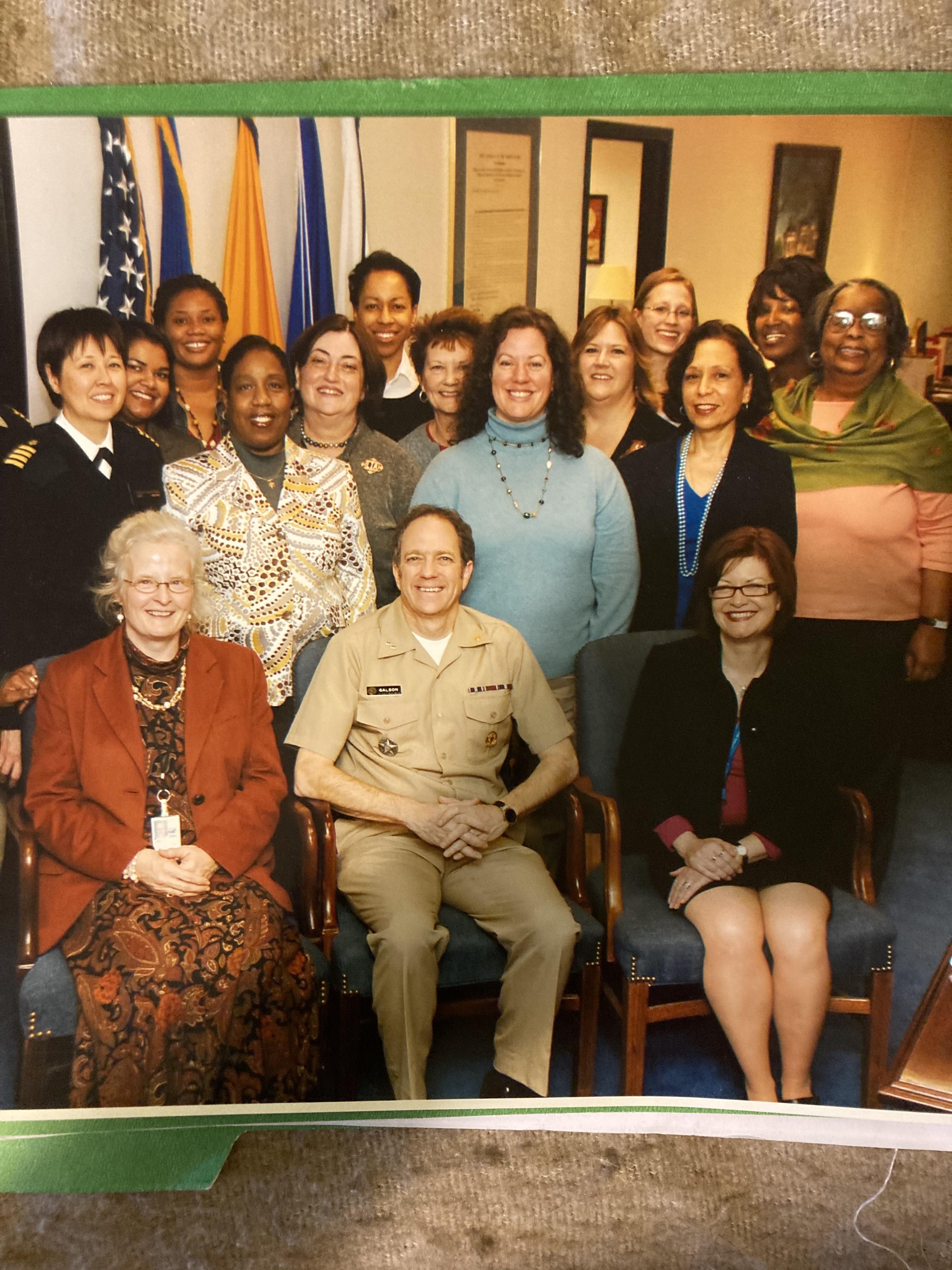 A man and women celebrate leadership and diversity in a military office, smiling together.