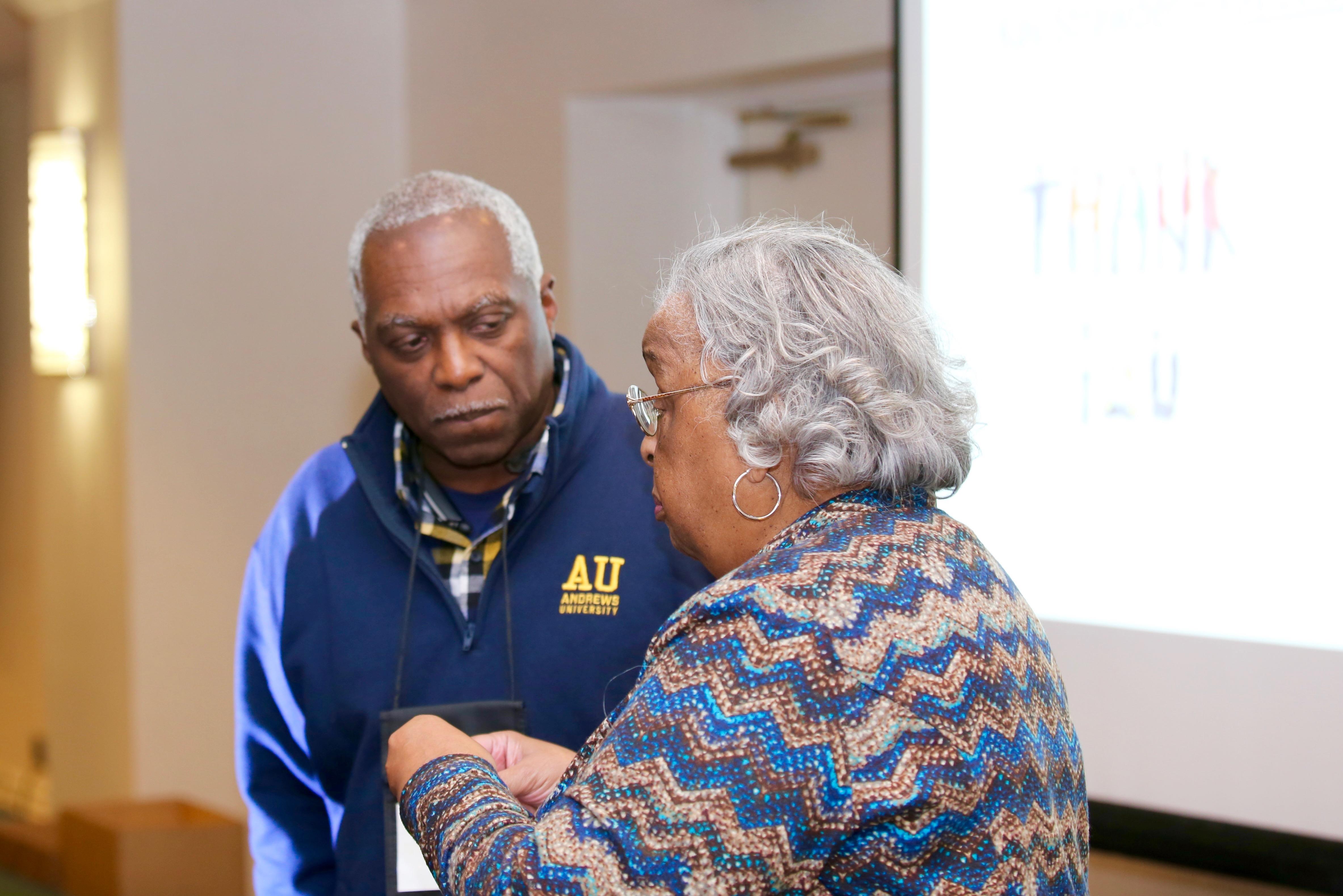 Two people engage in a deep discussion at a conference, showcasing connection.