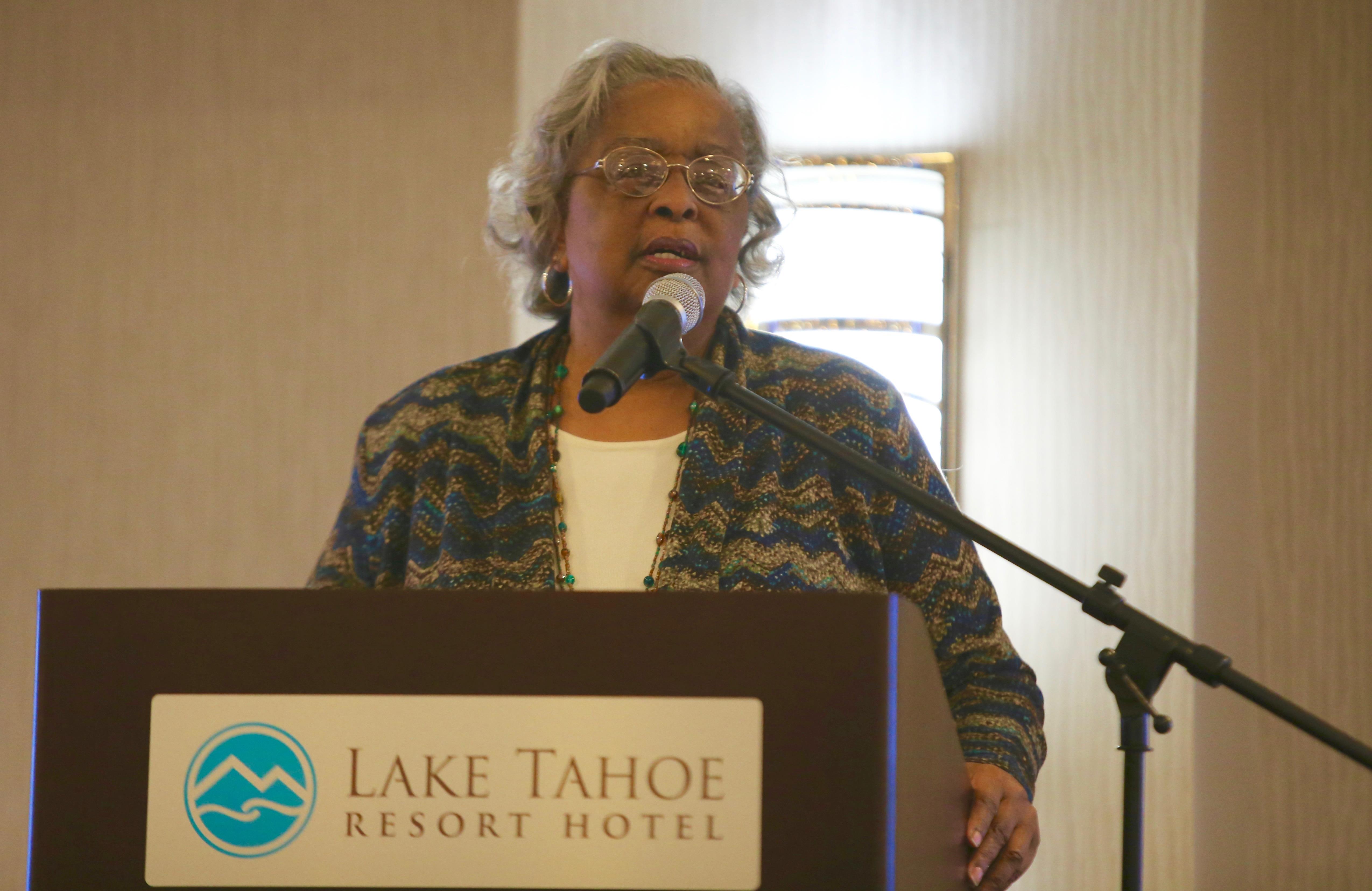 Senior woman passionately speaks at a Lake Tahoe event on social justice issues.