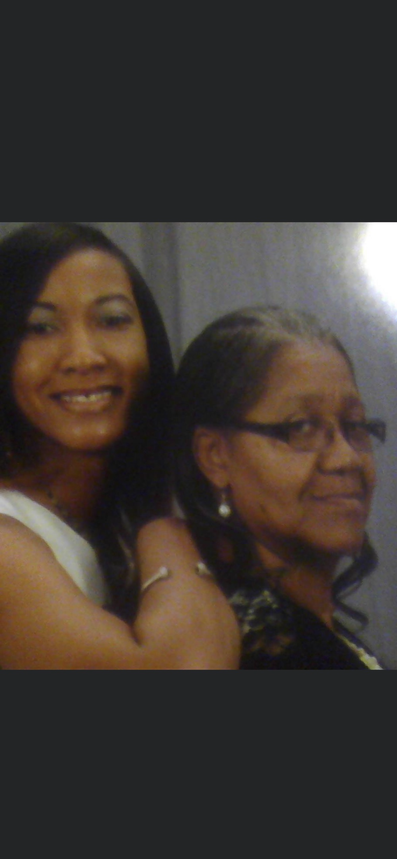 Two women smile joyfully, highlighting their connection and warmth in a festive atmosphere.