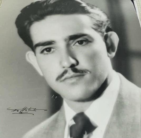 A young man poses for a formal portrait, showing a confident demeanor and classic style.