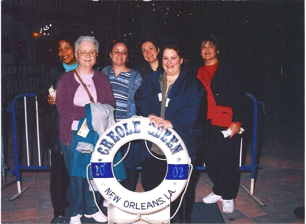 Friends gather for a joyful moment at the Creole Queen station in New Orleans during the evening.