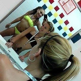 Friends enjoy taking selfies together in a changing room after a fun day at a water park.