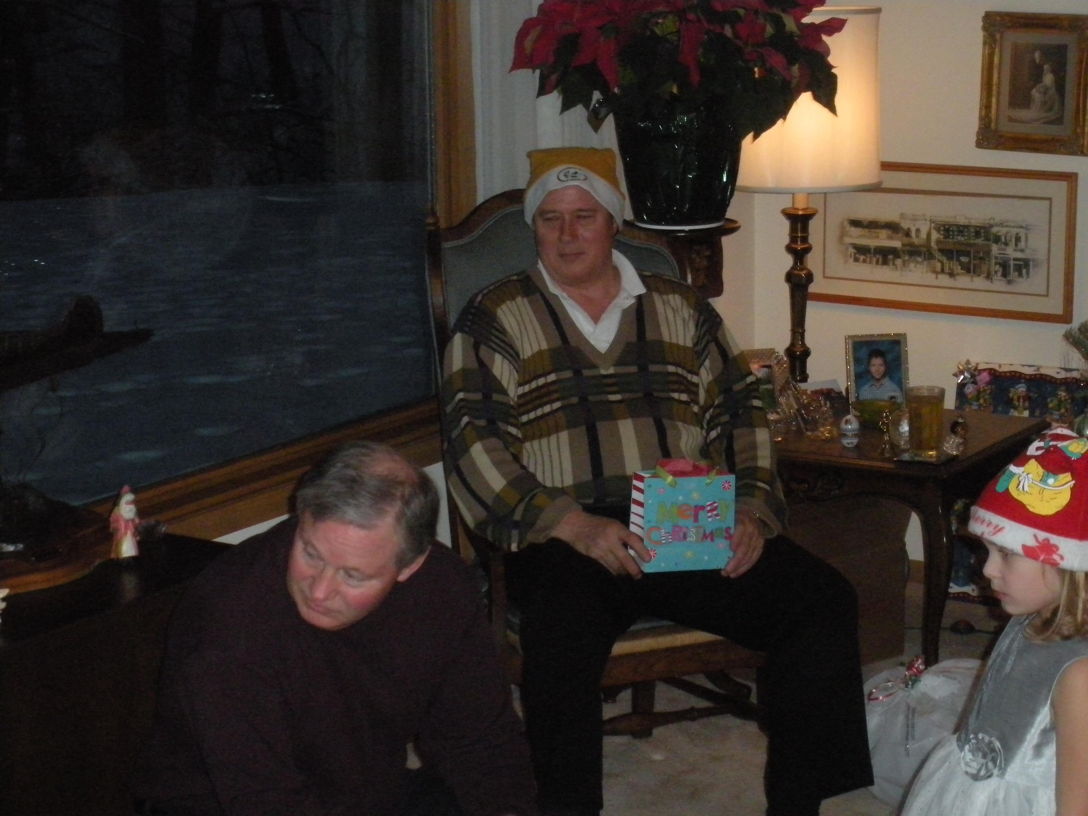 In a warm living room, family members share the joy of holiday gifts while reflecting on memories.
