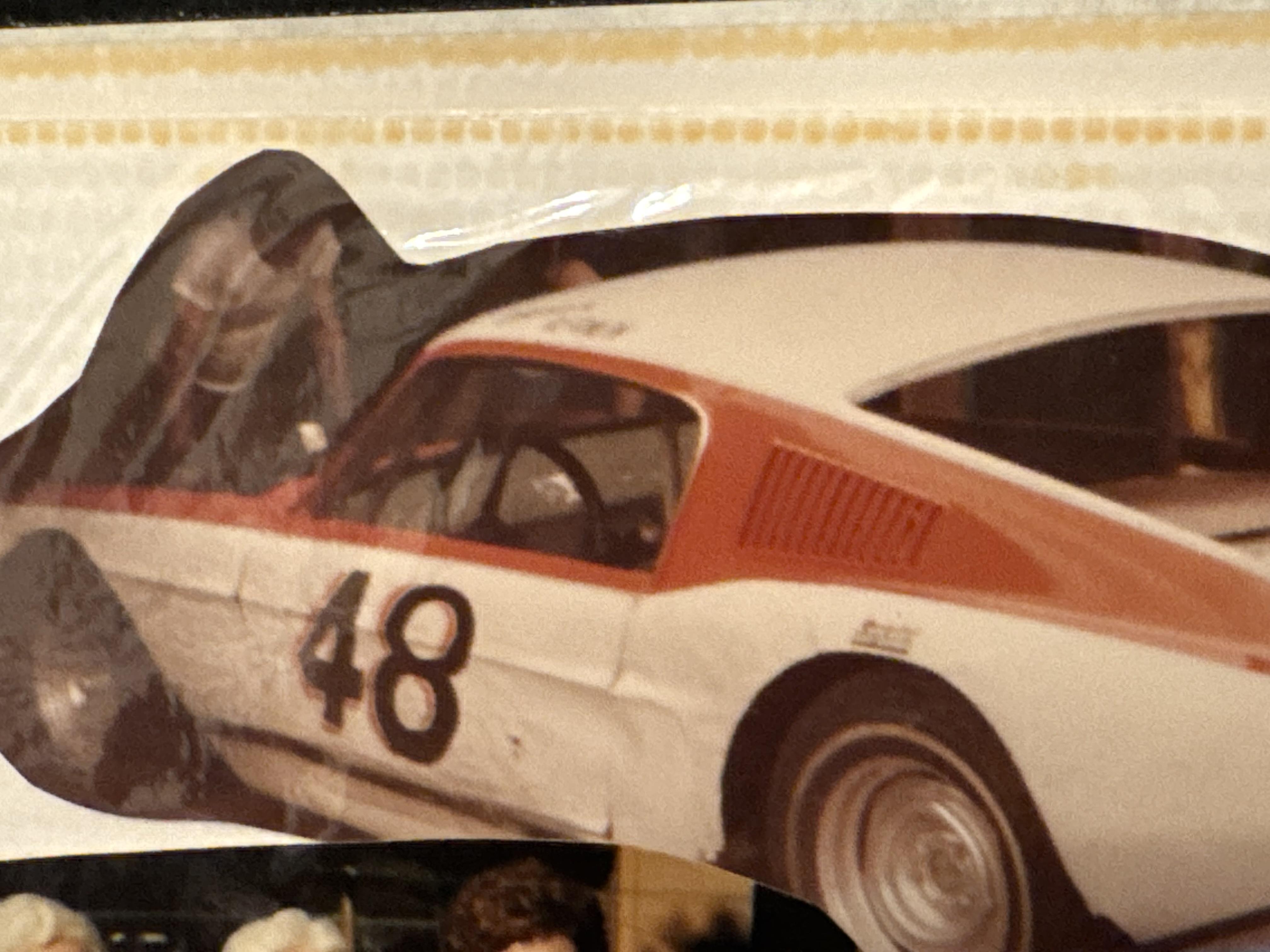 Classic racing car number 48 shines at a vibrant vintage car show with eager visitors.