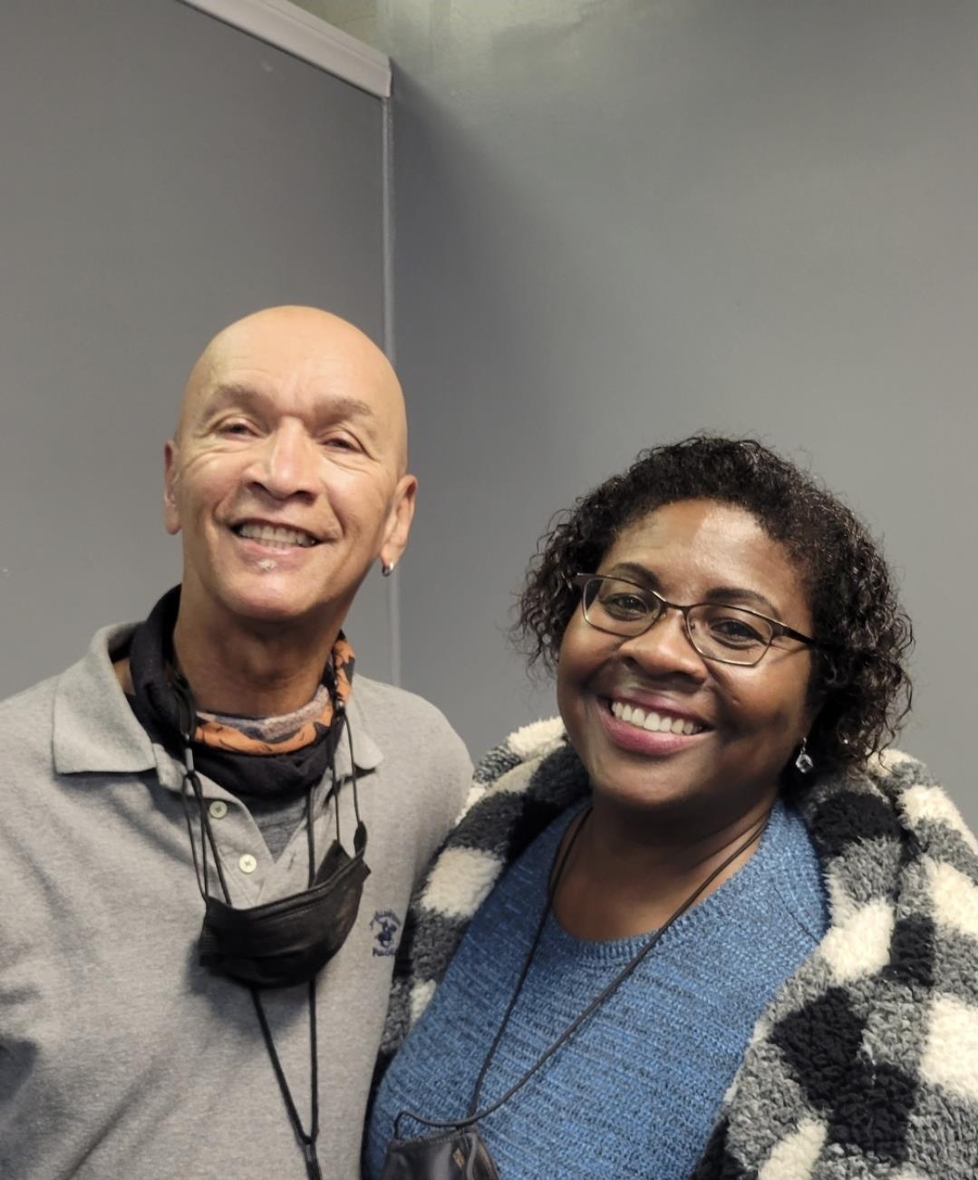 Two individuals are happily posing for a picture in a relaxed environment, showcasing friendship.