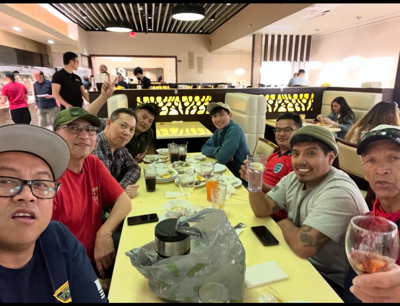 A group of friends gathers around a table, sharing drinks and smiles during a joyful dinner.