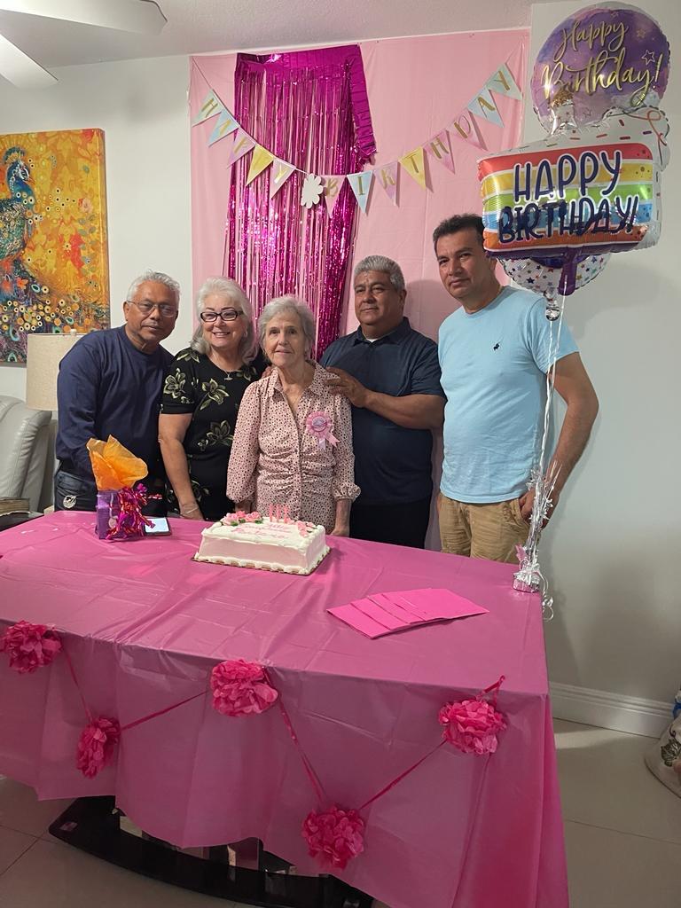 Family gathers to celebrate a special birthday, decorated with vibrant colors and festive balloons.
