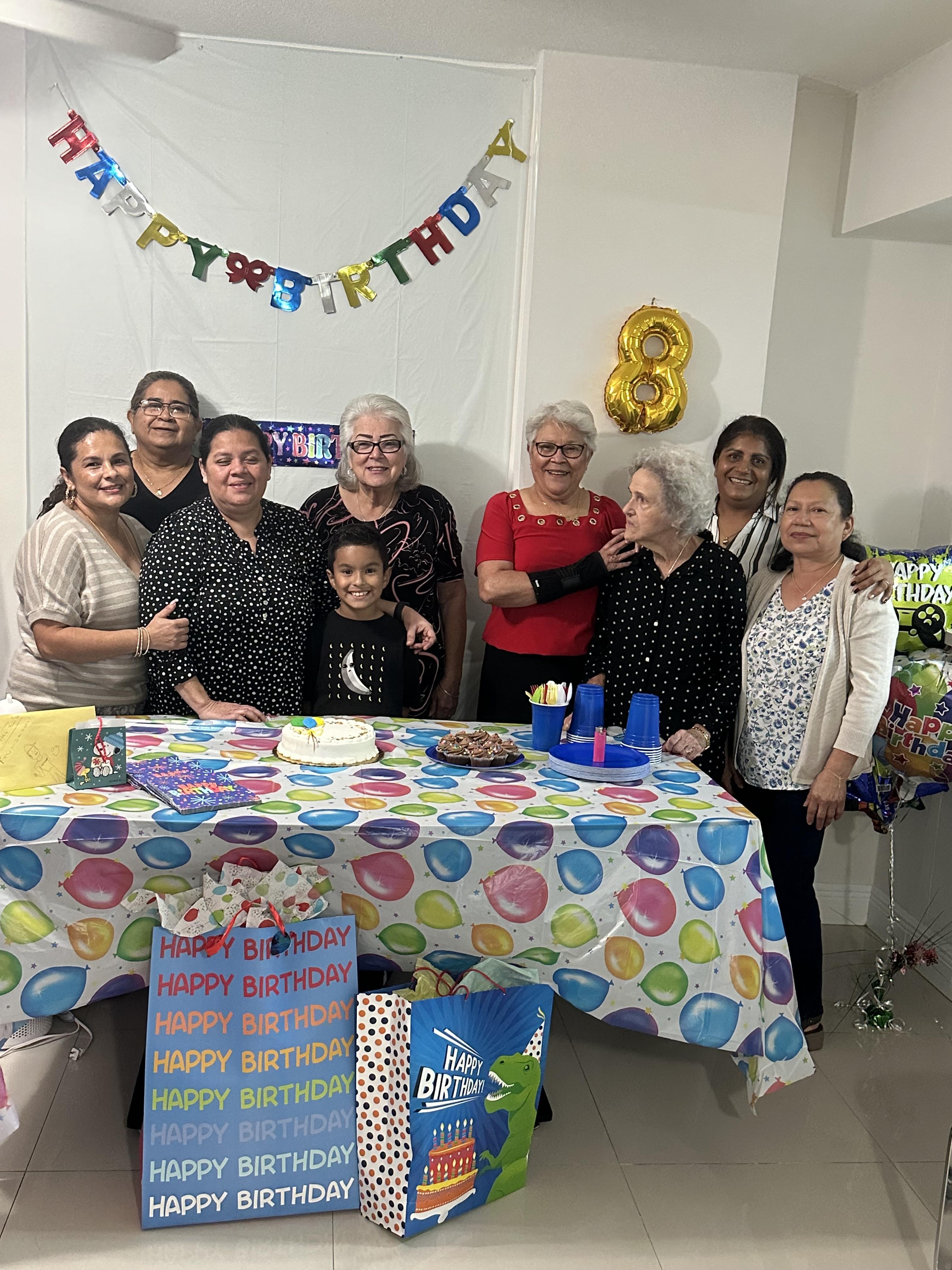 A vibrant birthday party with family, friends, cake, and decorations in a cozy home.