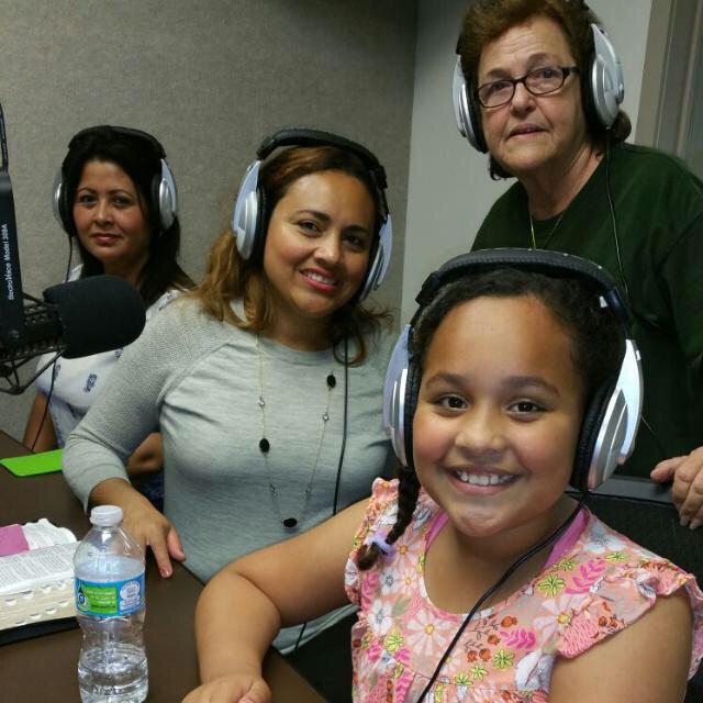 Women and a girl discuss cultural traditions while recording in a studio.