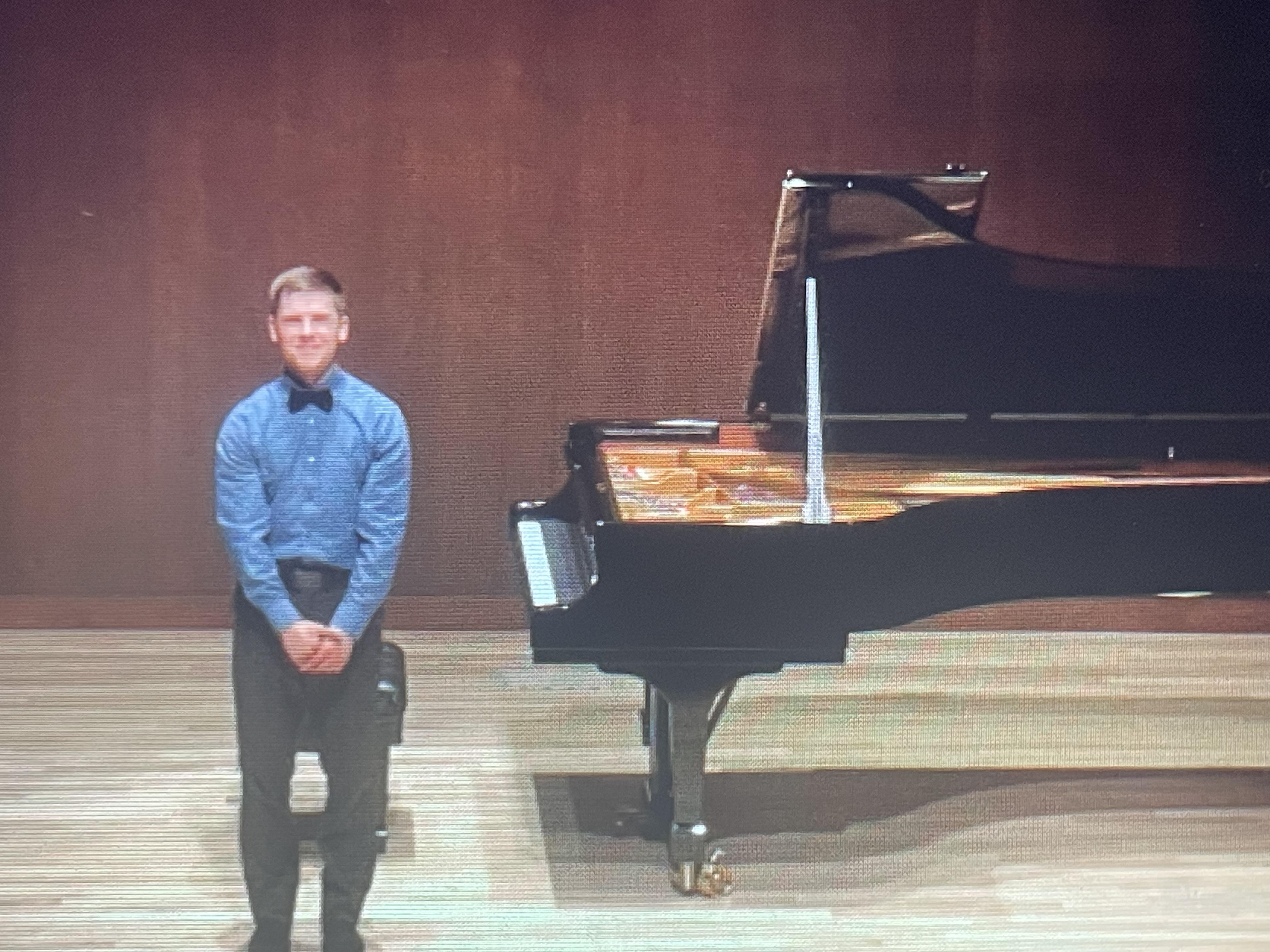 A man standing next to a piano