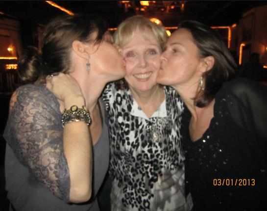 A group of women kissing a woman's cheek
