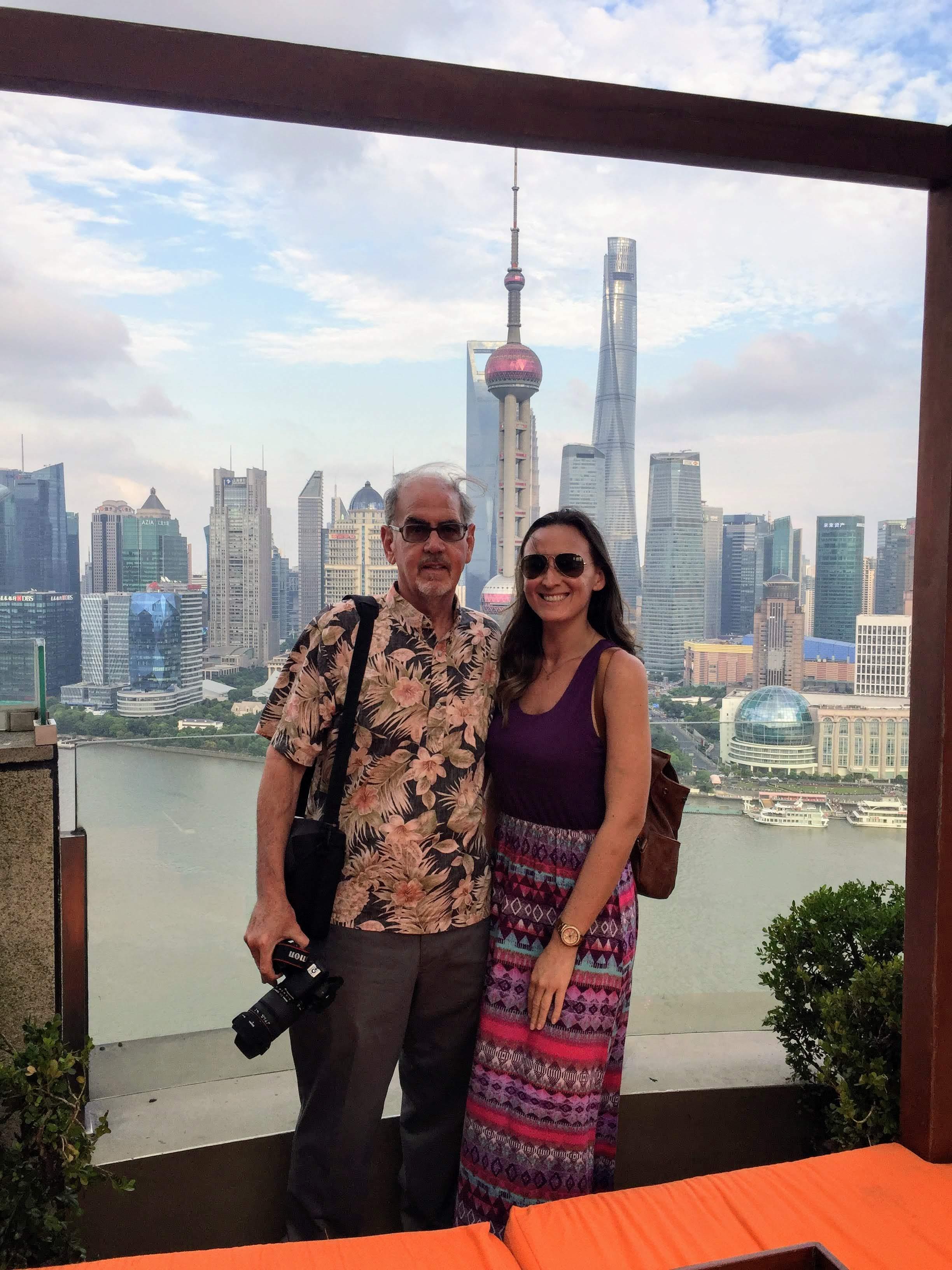 Visitors pose against the vibrant Shanghai skyline, capturing a moment of joy and exploration.