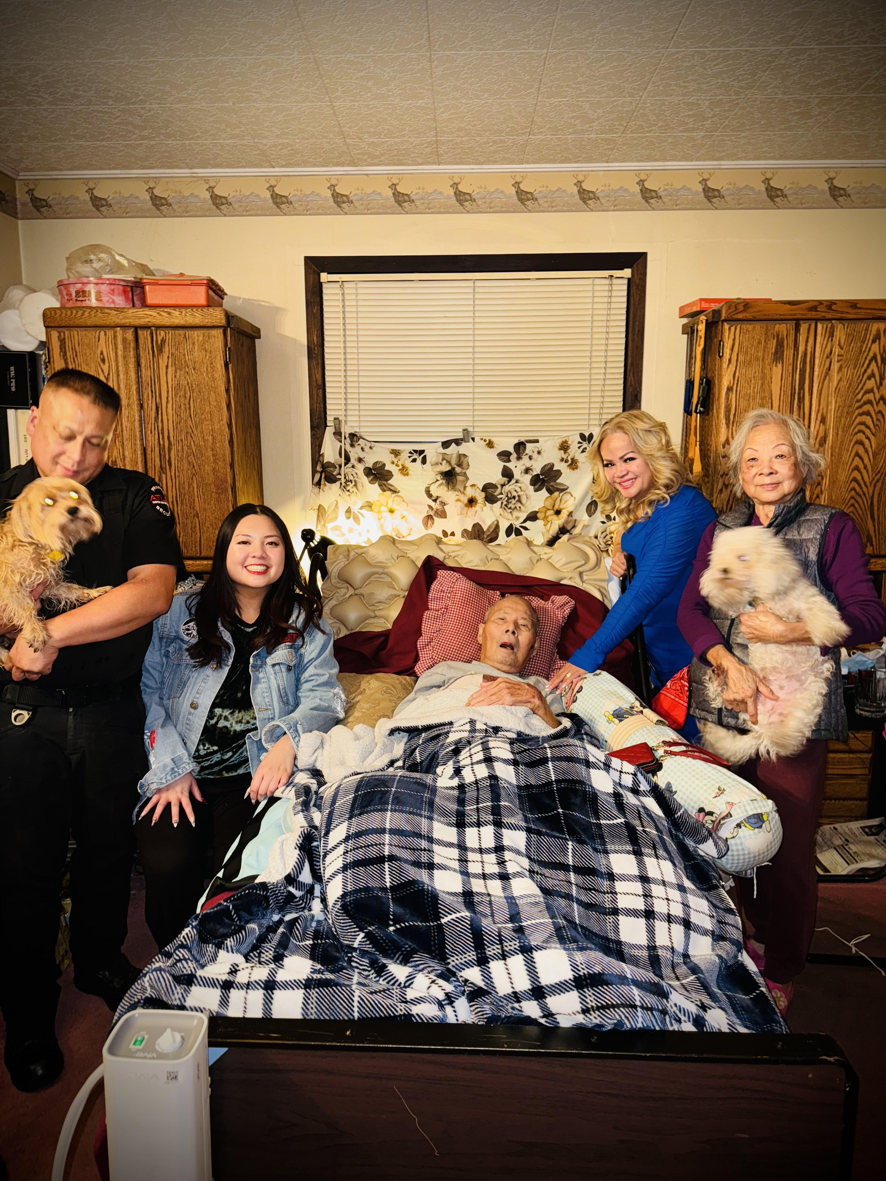 Loved ones come together in a warm setting to cherish moments with an elderly family member.