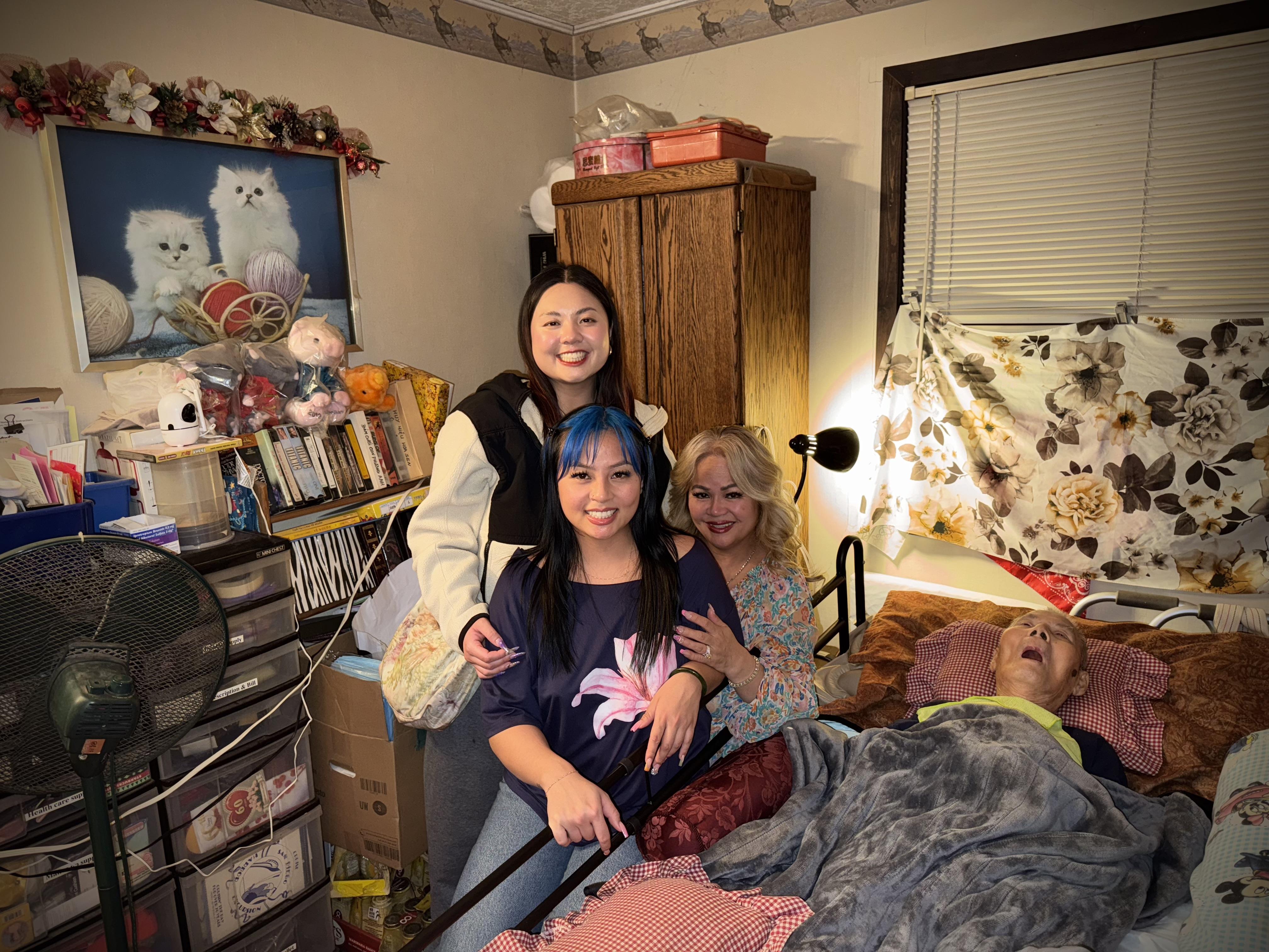 Four family members share a joyful moment in a warm, inviting bedroom during an evening visit.