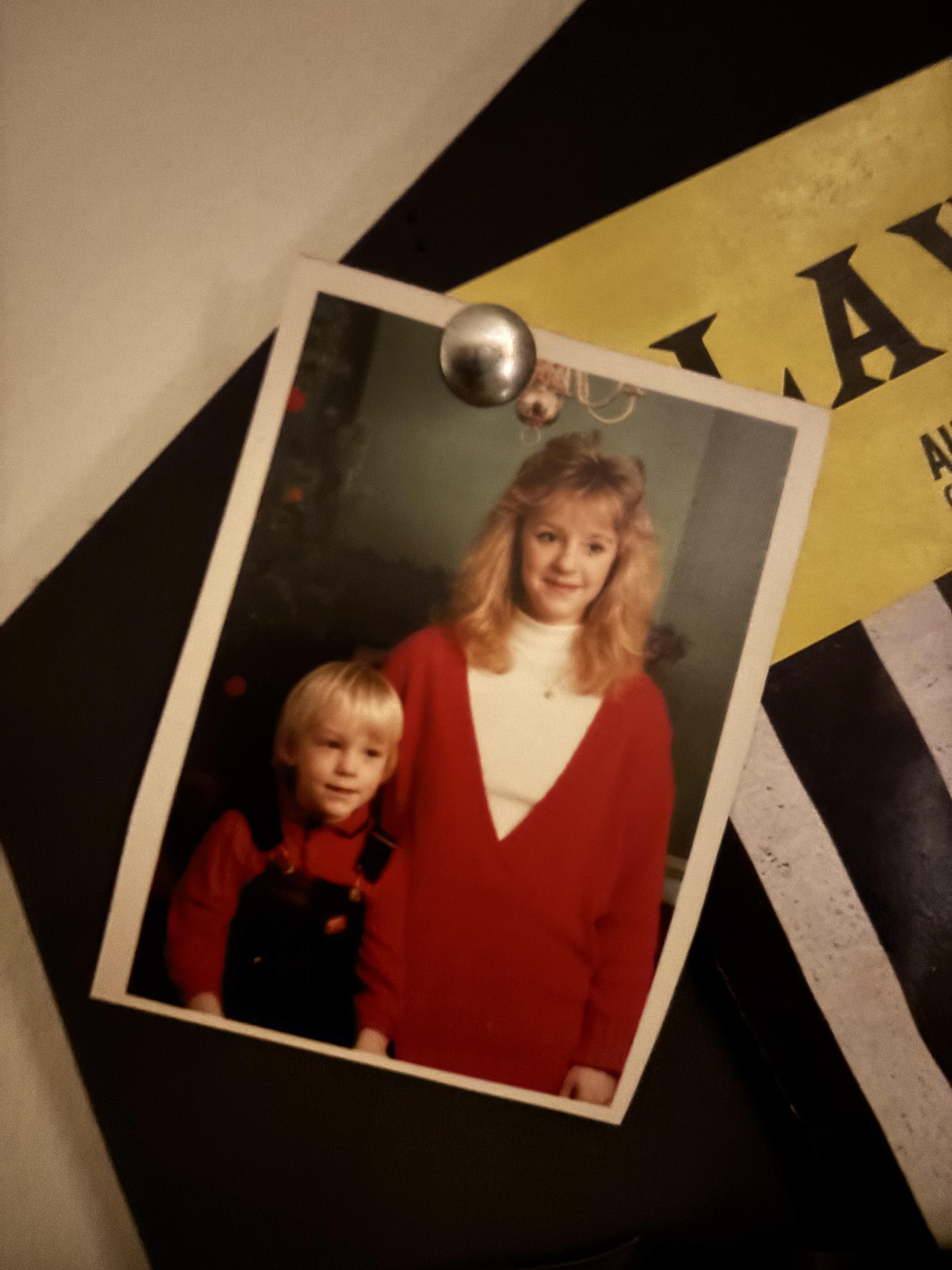A boy and his sister smile in colorful outfits, enjoying a warm atmosphere together.
