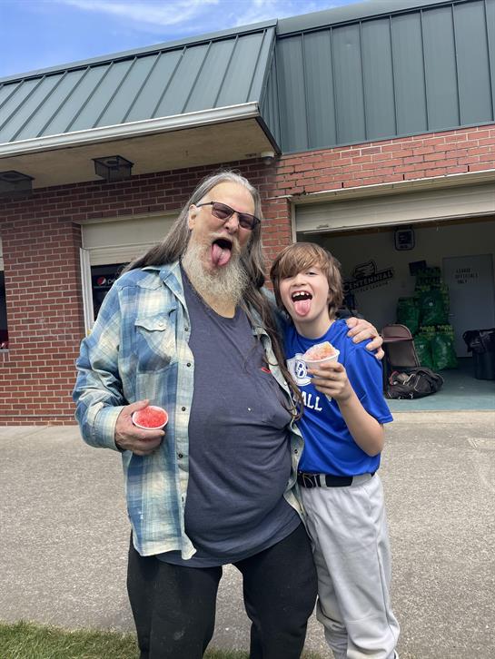 A man and boy sticking their tongue out